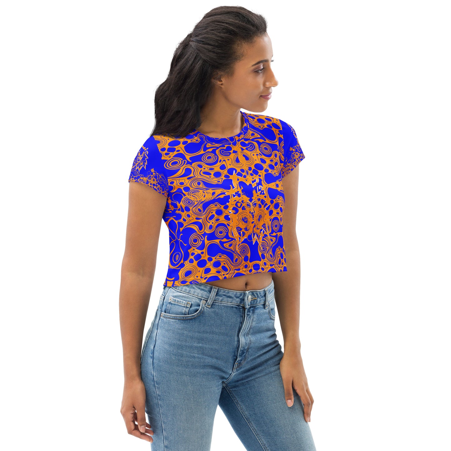A model wearing bold blue and orange crop t-shirt from Kloe Store featuring intricate abstract patterns and a central artistic face design, offering a stylish and edgy streetwear look.
