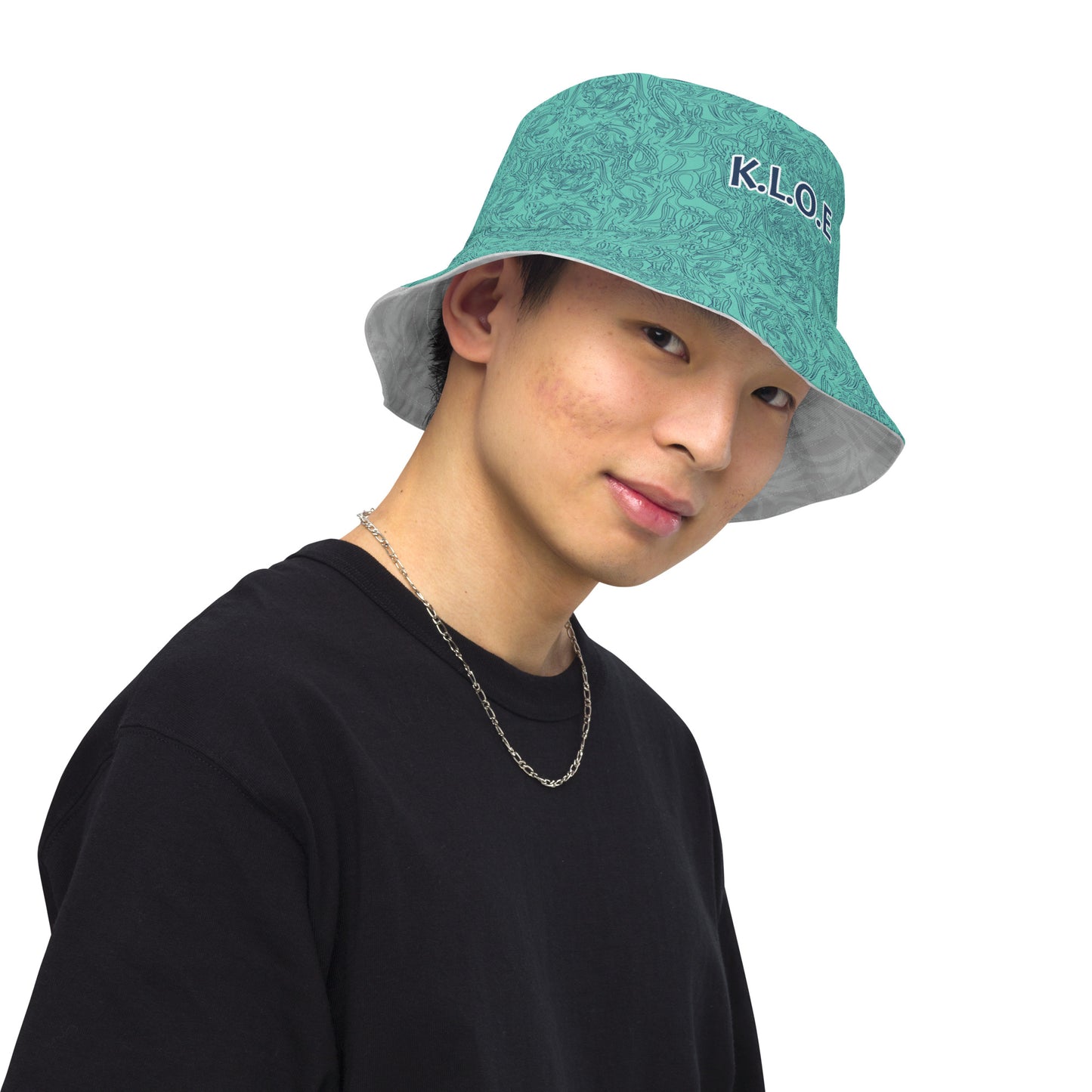 Reversible bucket hat with abstract jade and white linework, featuring dual-face artwork on one side and K.L.O.E logo on the other—crafted for bold, expressive style.
