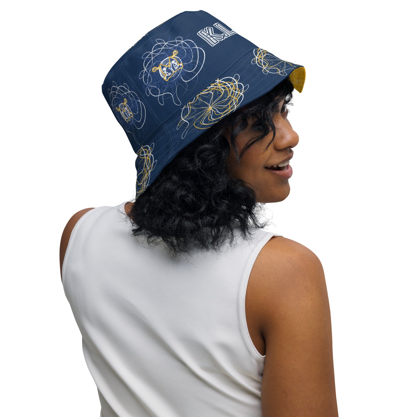 Reversible bucket hat featuring navy and golden yellow sides with abstract white linework and mirrored face emblems, blending hand-drawn cultural art with bold, expressive streetwear style.