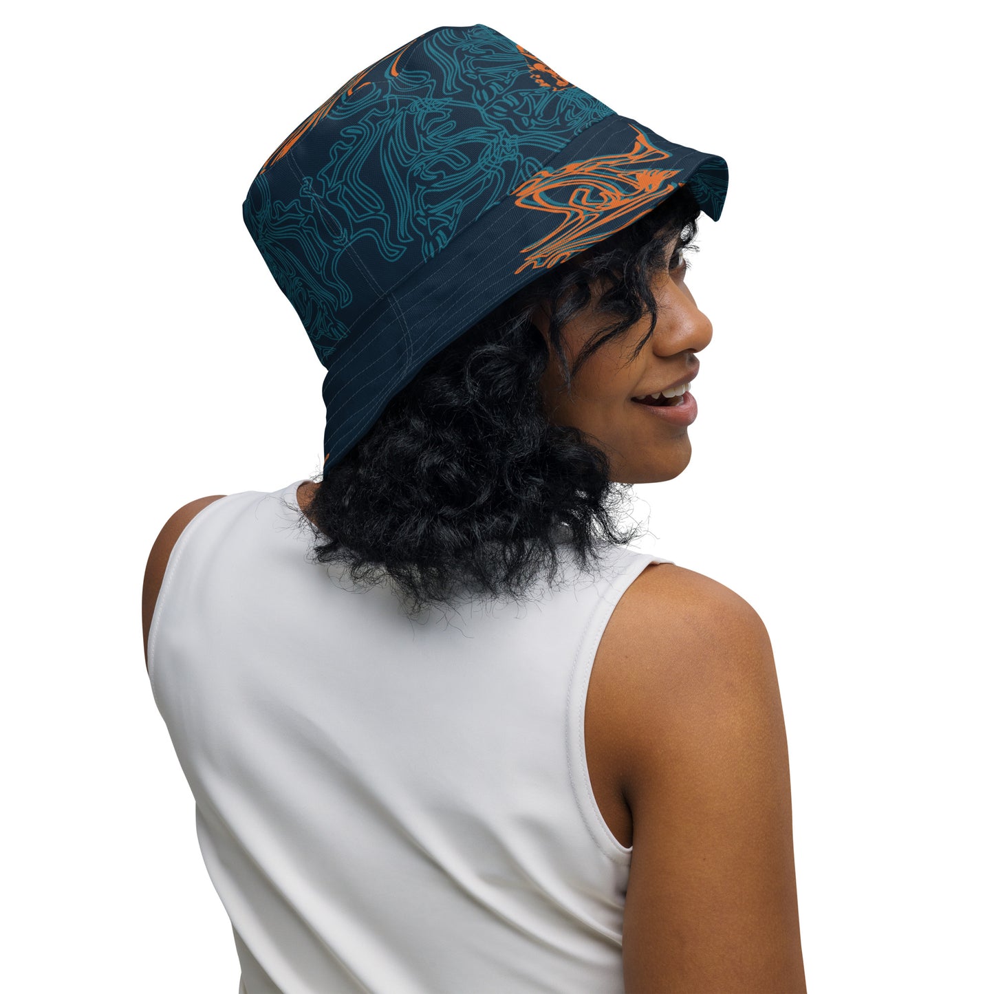 Reversible bucket hat featuring a small orange mirrored face motif and bold tribal-inspired patterns, blending art and streetwear.