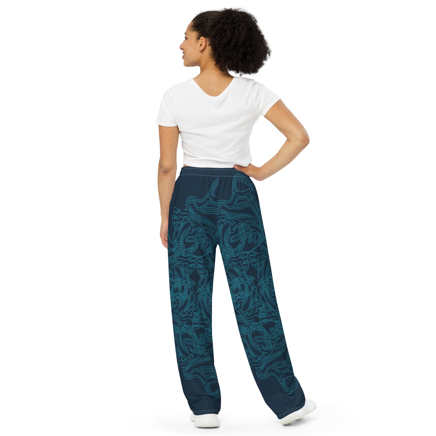 Navy blue wide-leg pants featuring intricate cyan linework, creating a fluid and artistic pattern for a bold statement look, on a model.