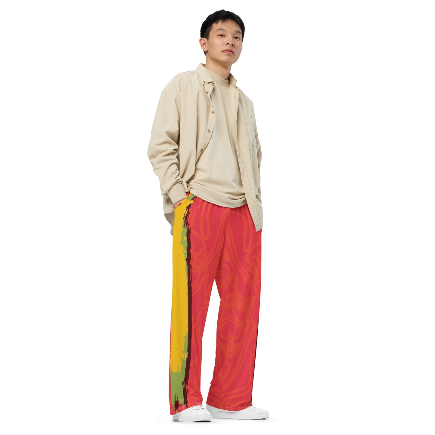 Wide-leg pants with a red base and abstract brushstroke side panels in yellow, green, and black, inspired by bold color play and cultural expression.