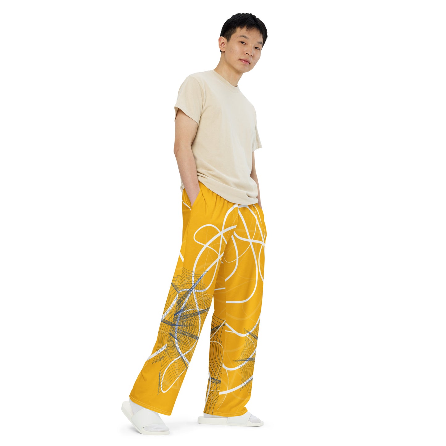 Golden yellow wide-leg pants featuring flowing white abstract line art and navy geometric patterns, merging expressive streetwear style with hand-drawn design from the Secret Chambers of I and I collection.