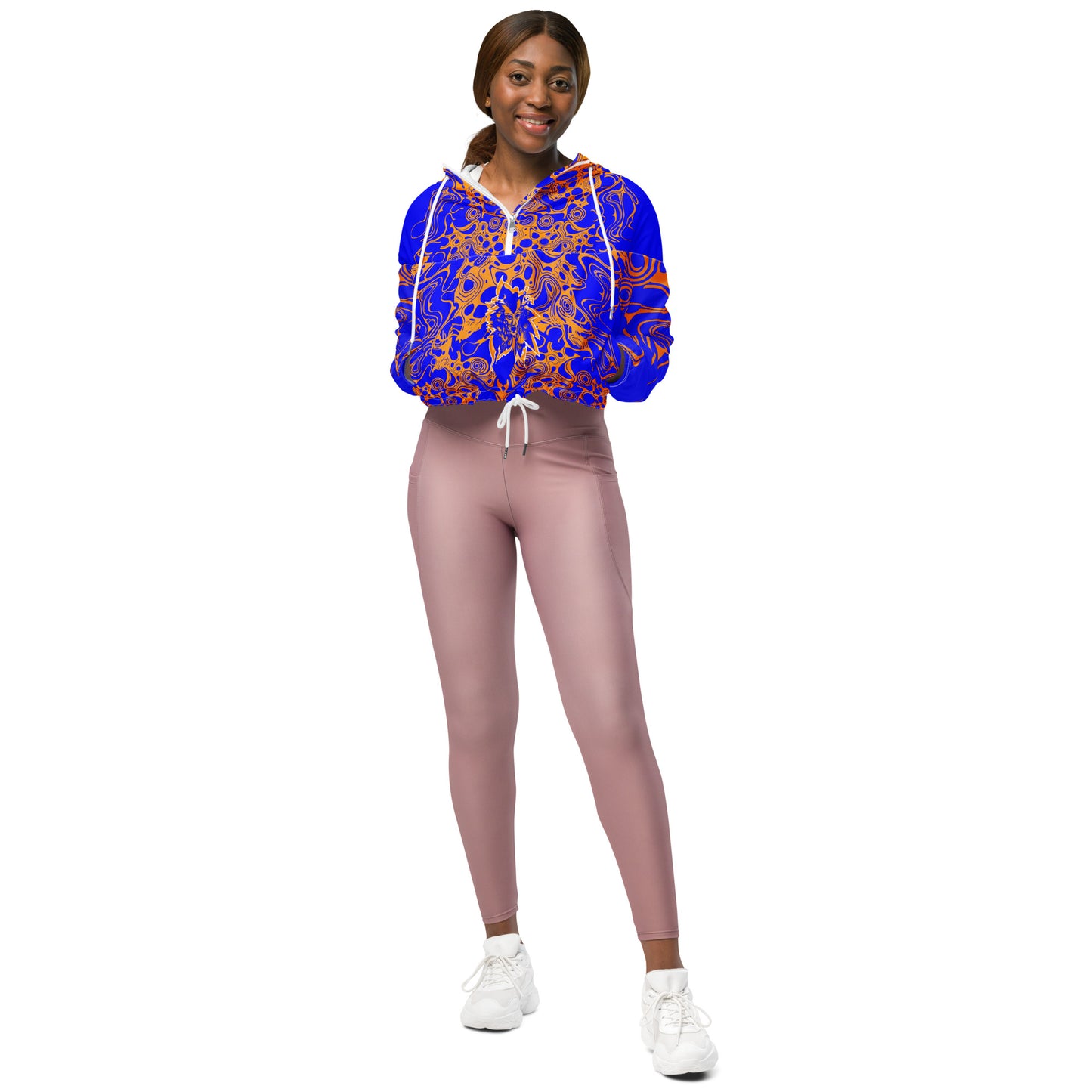 Product mockup - model wearing a vibrant blue and orange cropped windbreaker from Kloe Store featuring abstract swirl pattern, a front zipper, drawstring hood, and elastic cuffs, offering a stylish and modern streetwear look.
