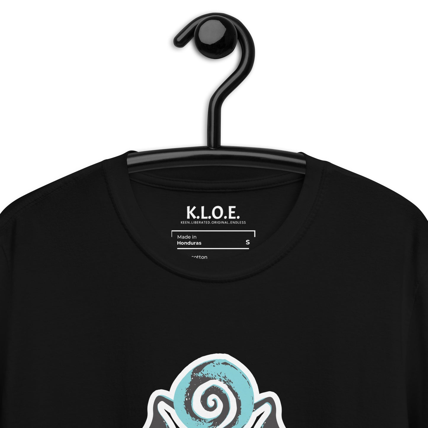 A model wearing black K.L.O.E. t-shirt showcasing a hand-drawn design of two mirrored faces in black and teal, embodying culturally inspired, bohemian style fashion focused on individuality and artistic expression, detail view, showing the inside label.