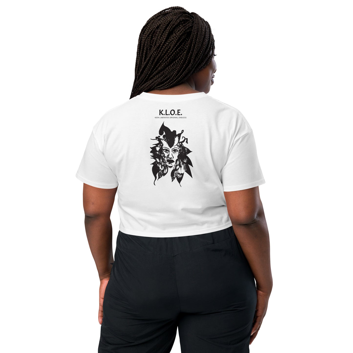 Back view of a white K.L.O.E. crop t-shirt showcasing a culturally inspired, hand-drawn black design featuring a bold, expressive face intertwined with flowing, abstract patterns, and K.L.O.E. logo, embodying artistic self-expression and modern bohemian style fashion, on a model.