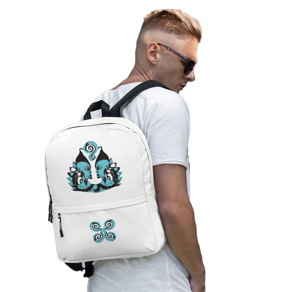 The model wearing a white backpack, featuring a hand-drawn, culturally inspired design of two mirrored faces in bold black and teal on the main panel, and an intricate teal spiral motif on the pocket, celebrating self-expression and individuality in modern bohemian style fashion by K.L.O.E.