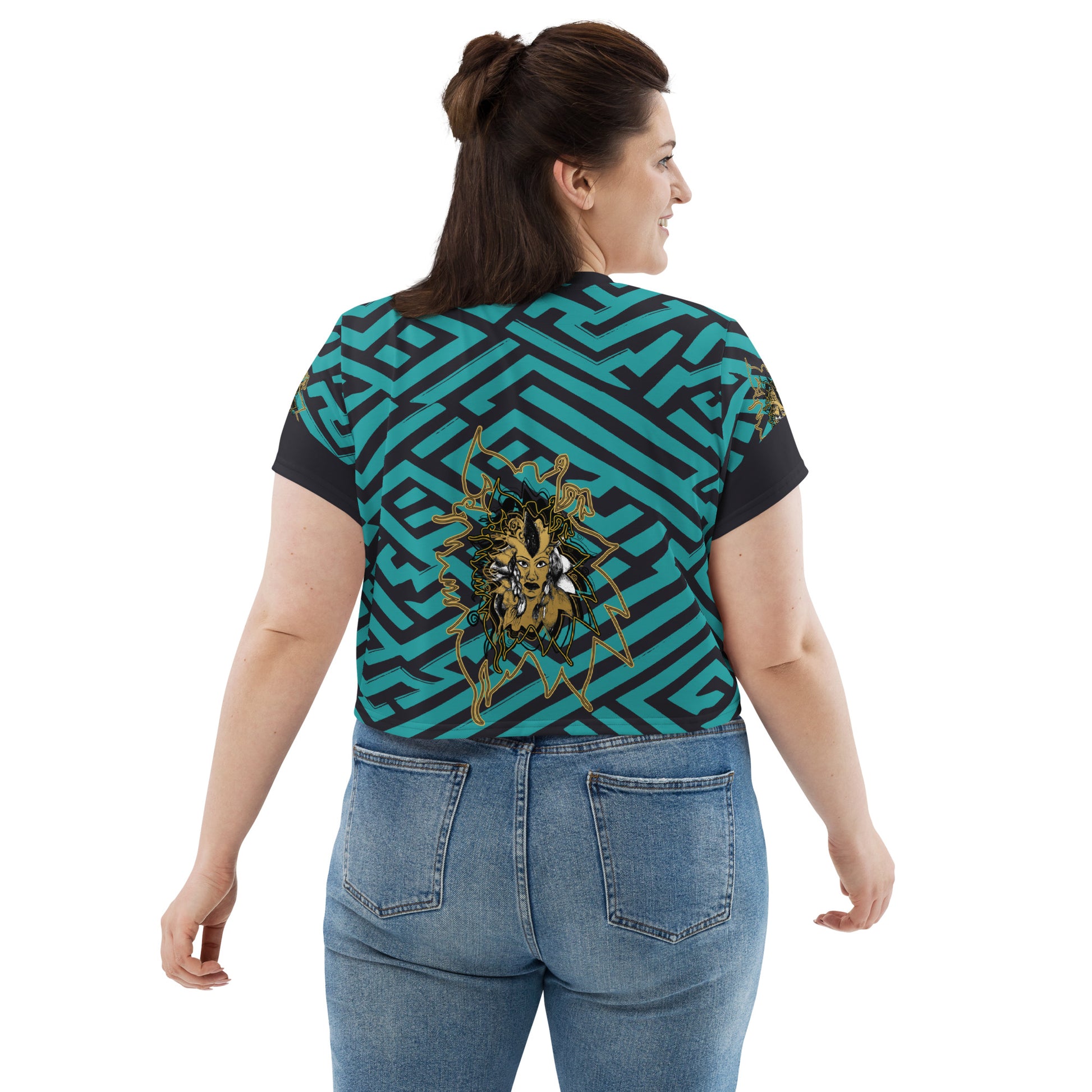 Back view of a vibrant blue and black geometric patterned crop top with a bold graphic centerpiece, plus size model.