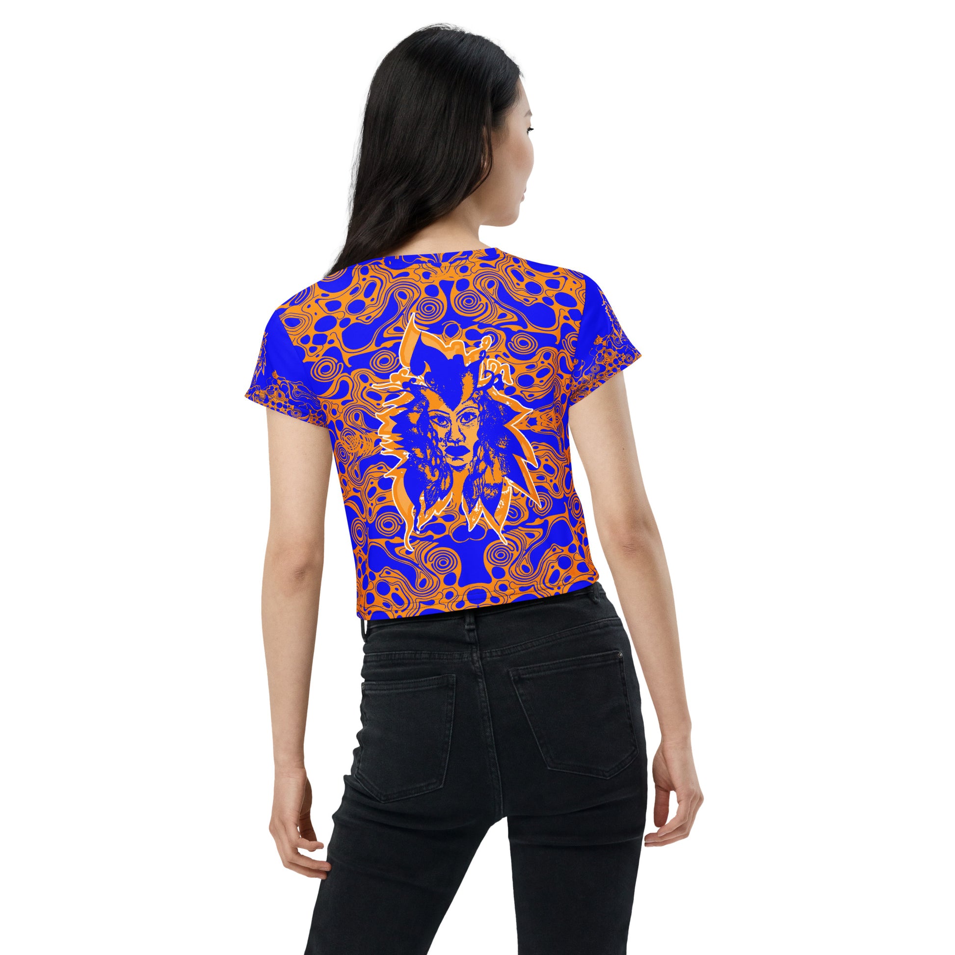 A model wearing bold blue and orange crop t-shirt from Kloe Store featuring intricate abstract patterns and a central artistic face design, offering a stylish and edgy streetwear look.