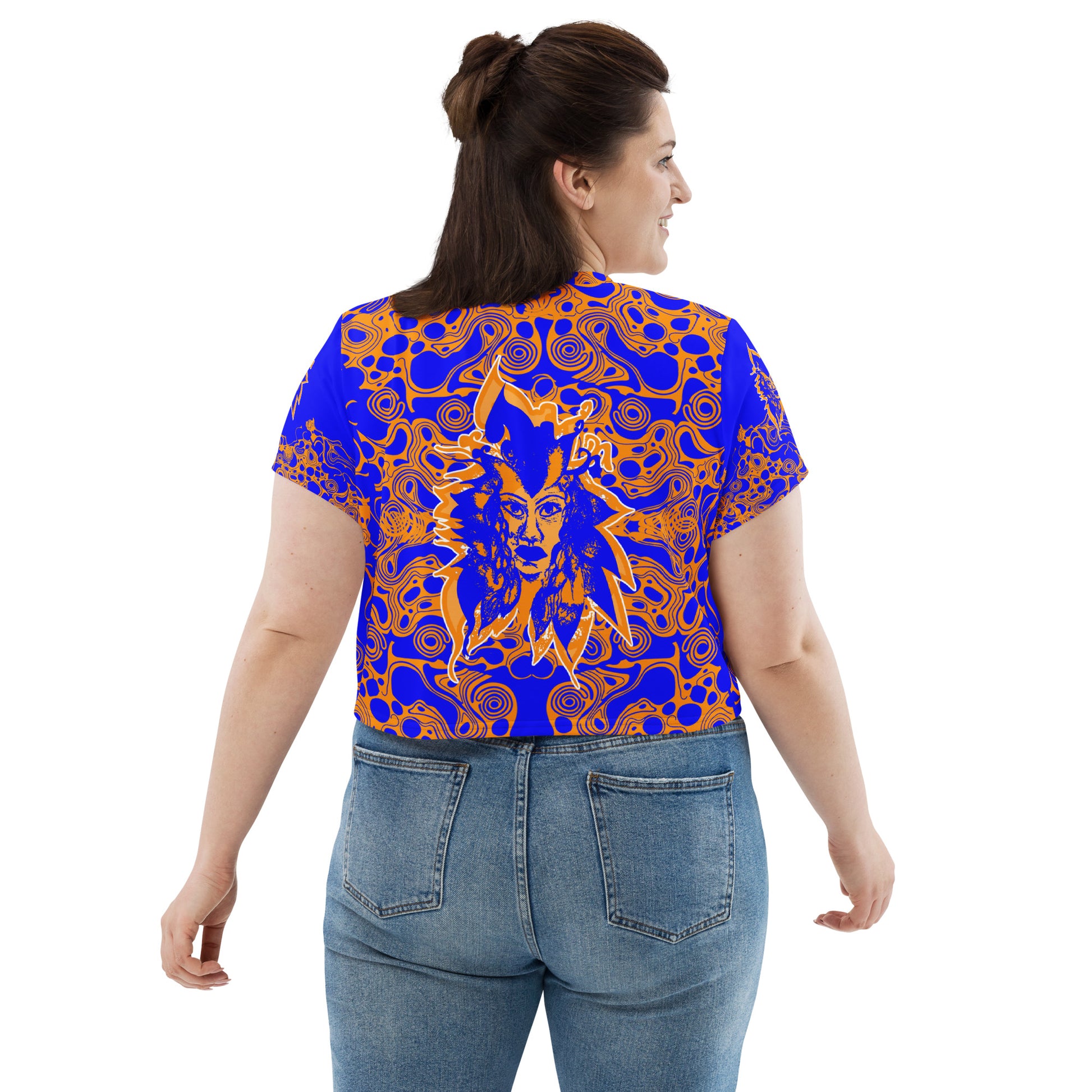 A model wearing bold blue and orange crop t-shirt from Kloe Store featuring intricate abstract patterns and a central artistic face design, offering a stylish and edgy streetwear look.