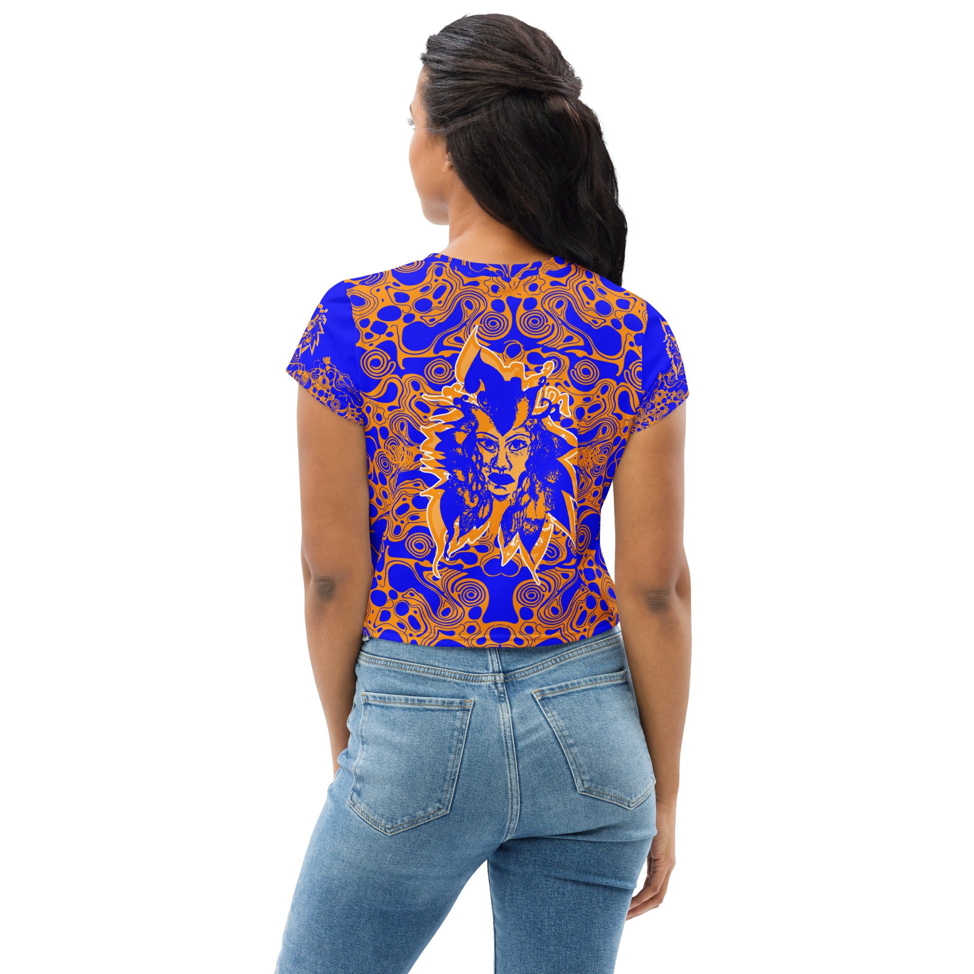 A model wearing bold blue and orange crop t-shirt from Kloe Store featuring intricate abstract patterns and a central artistic face design, offering a stylish and edgy streetwear look.