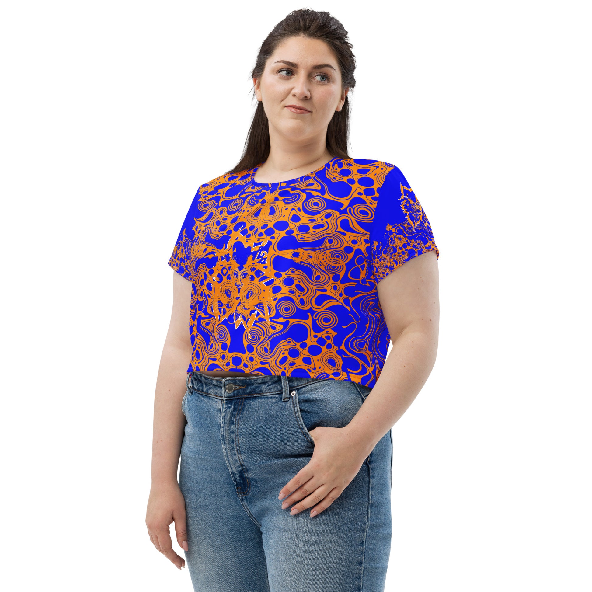 A model wearing bold blue and orange crop t-shirt from Kloe Store featuring intricate abstract patterns and a central artistic face design, offering a stylish and edgy streetwear look.