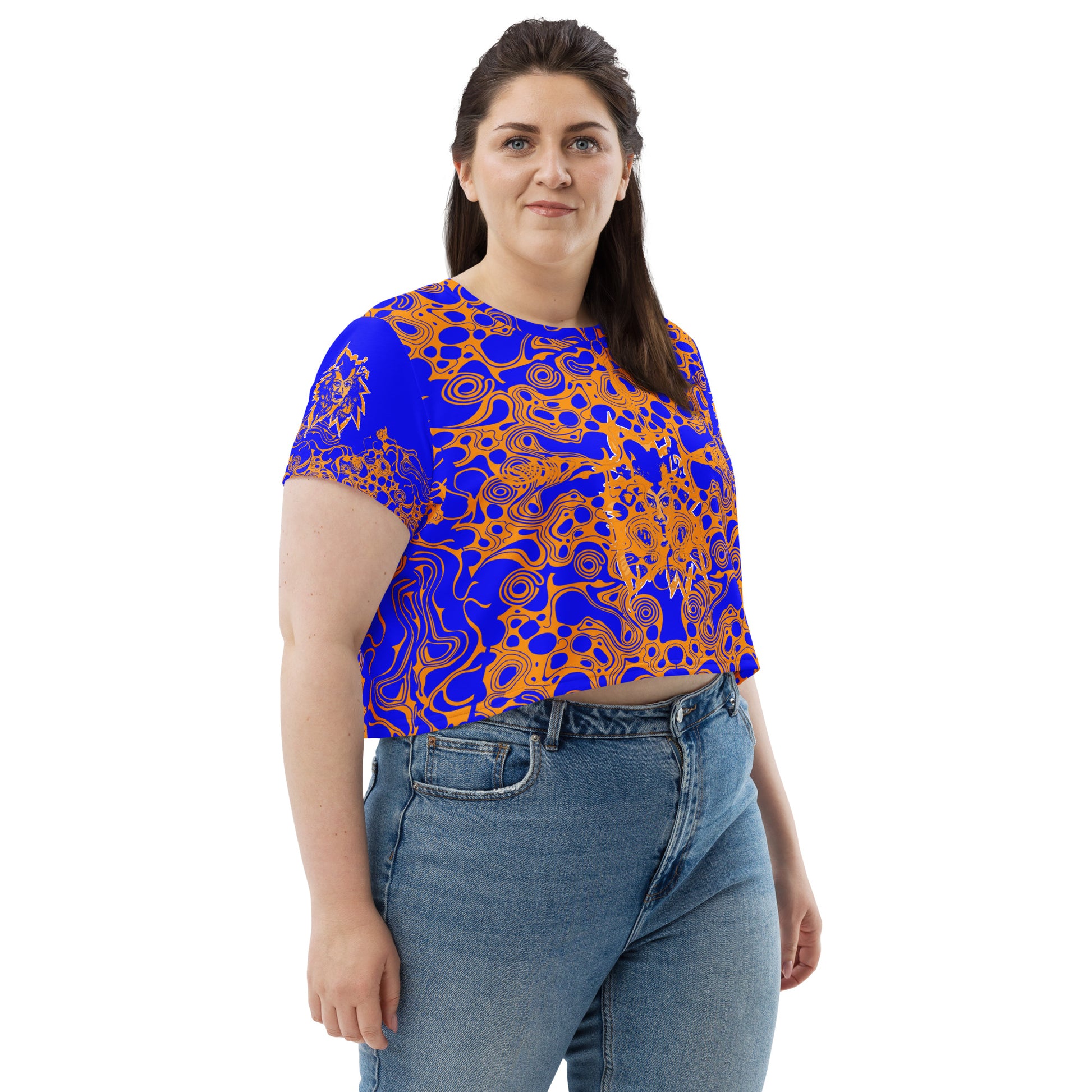 A model wearing bold blue and orange crop t-shirt from Kloe Store featuring intricate abstract patterns and a central artistic face design, offering a stylish and edgy streetwear look.