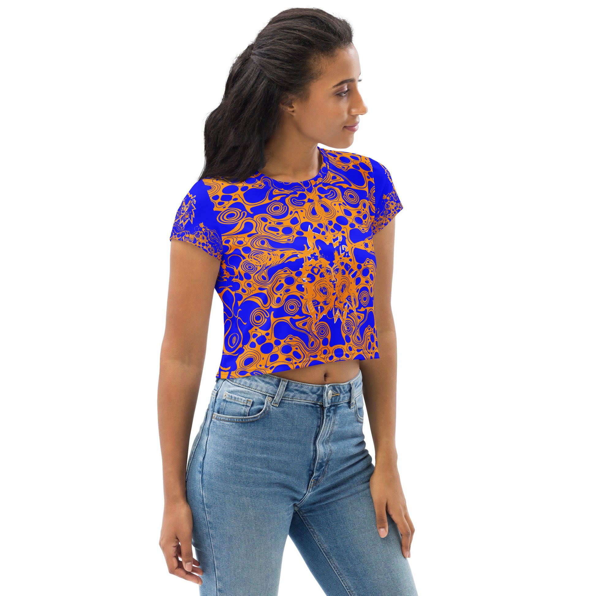 A model wearing bold blue and orange crop t-shirt from Kloe Store featuring intricate abstract patterns and a central artistic face design, offering a stylish and edgy streetwear look.