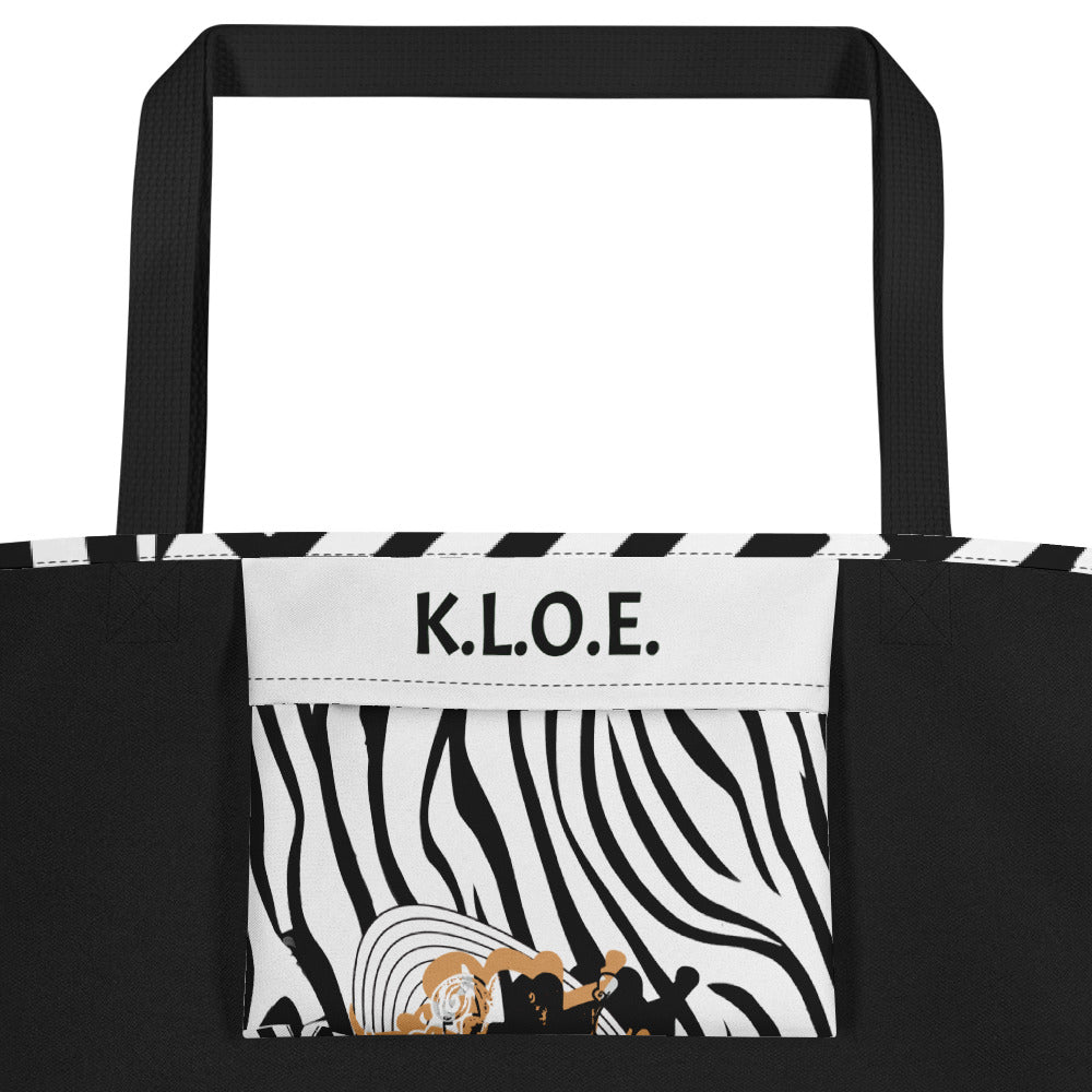 Large black and white tote bag from Kloe Store featuring bold geometric and zebra patterns with an artistic face design and with black straps, stylish and functional for everyday use, inside pocket view.
