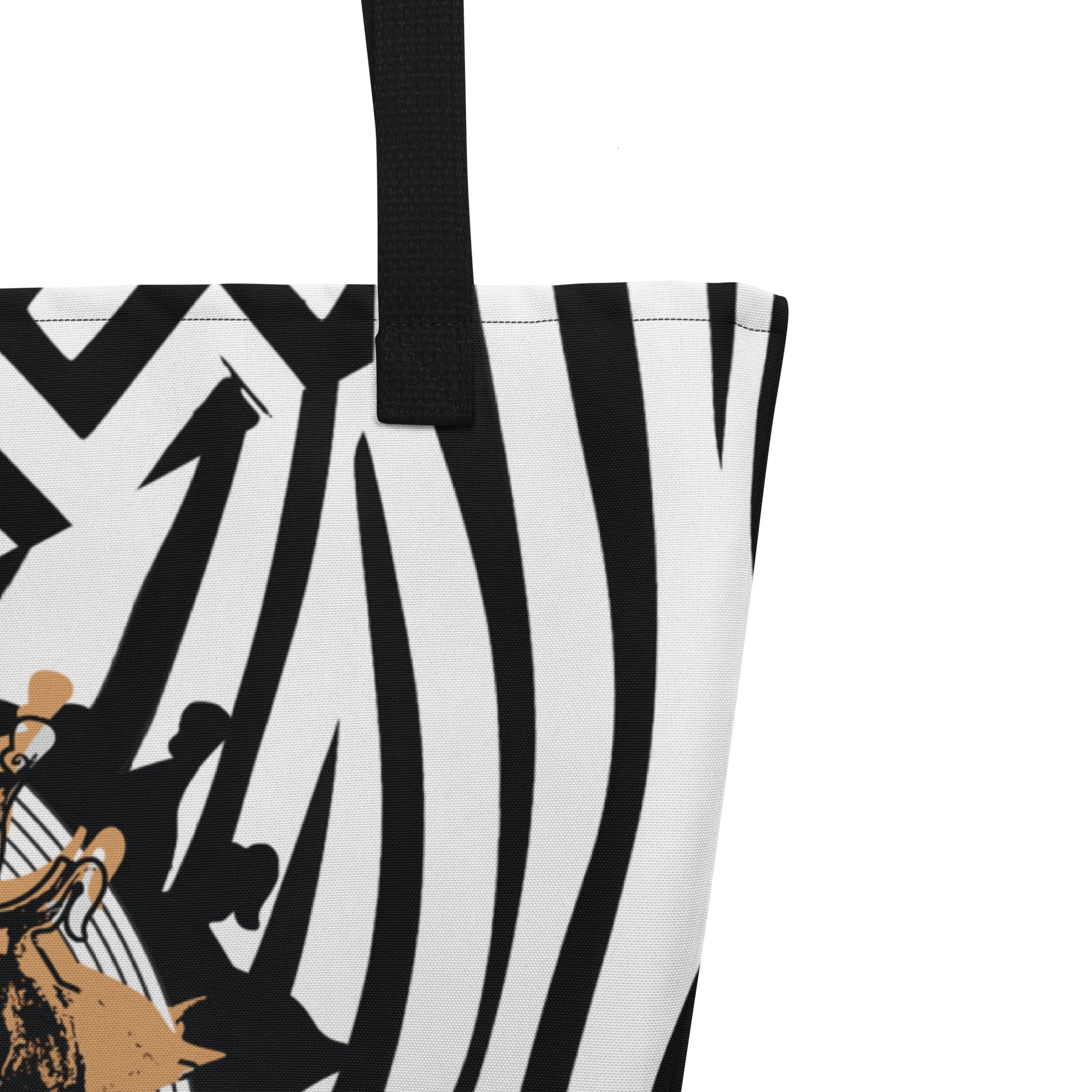 Large black and white tote bag from Kloe Store featuring bold geometric and zebra patterns with an artistic face design and with black straps, stylish and functional for everyday use, detail view.