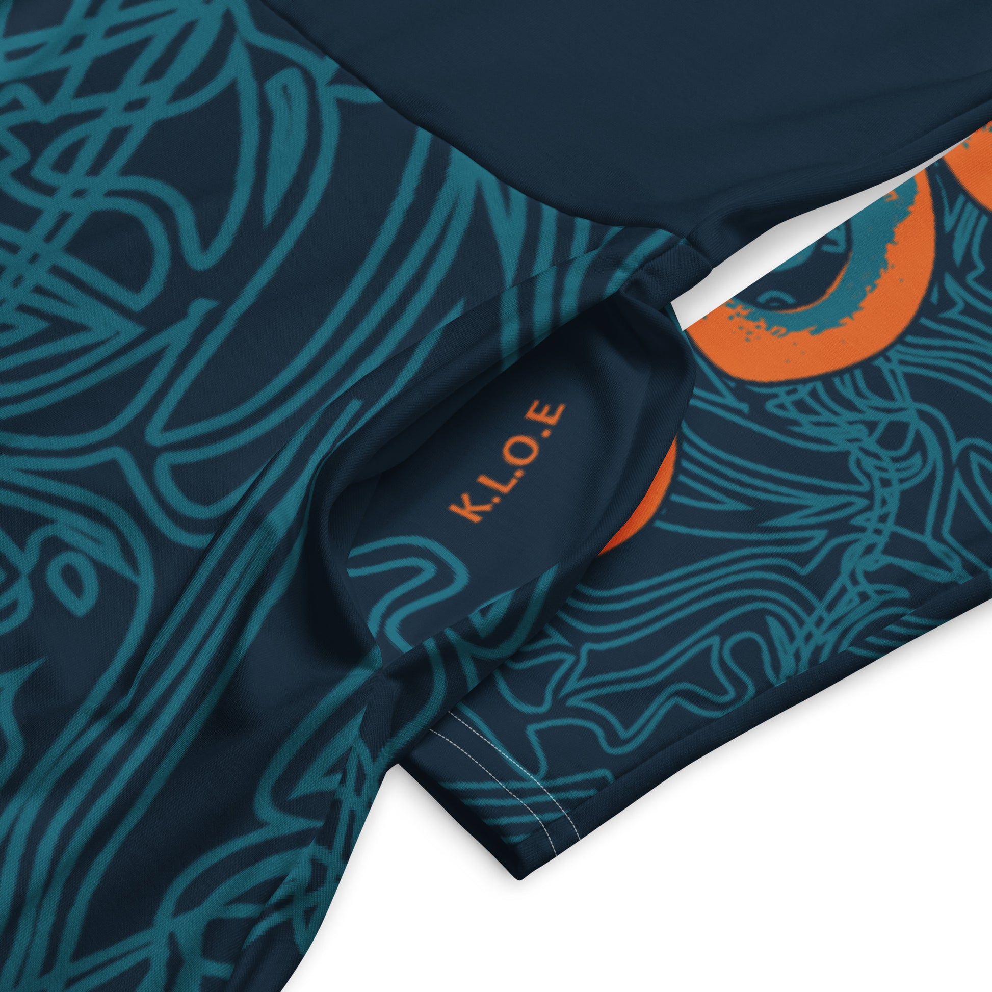 Pocket and details view of a navy blue long-sleeve dress with swirling cyan line art, bold orange sleeve accents, and a fit-and-flare design, on a model.