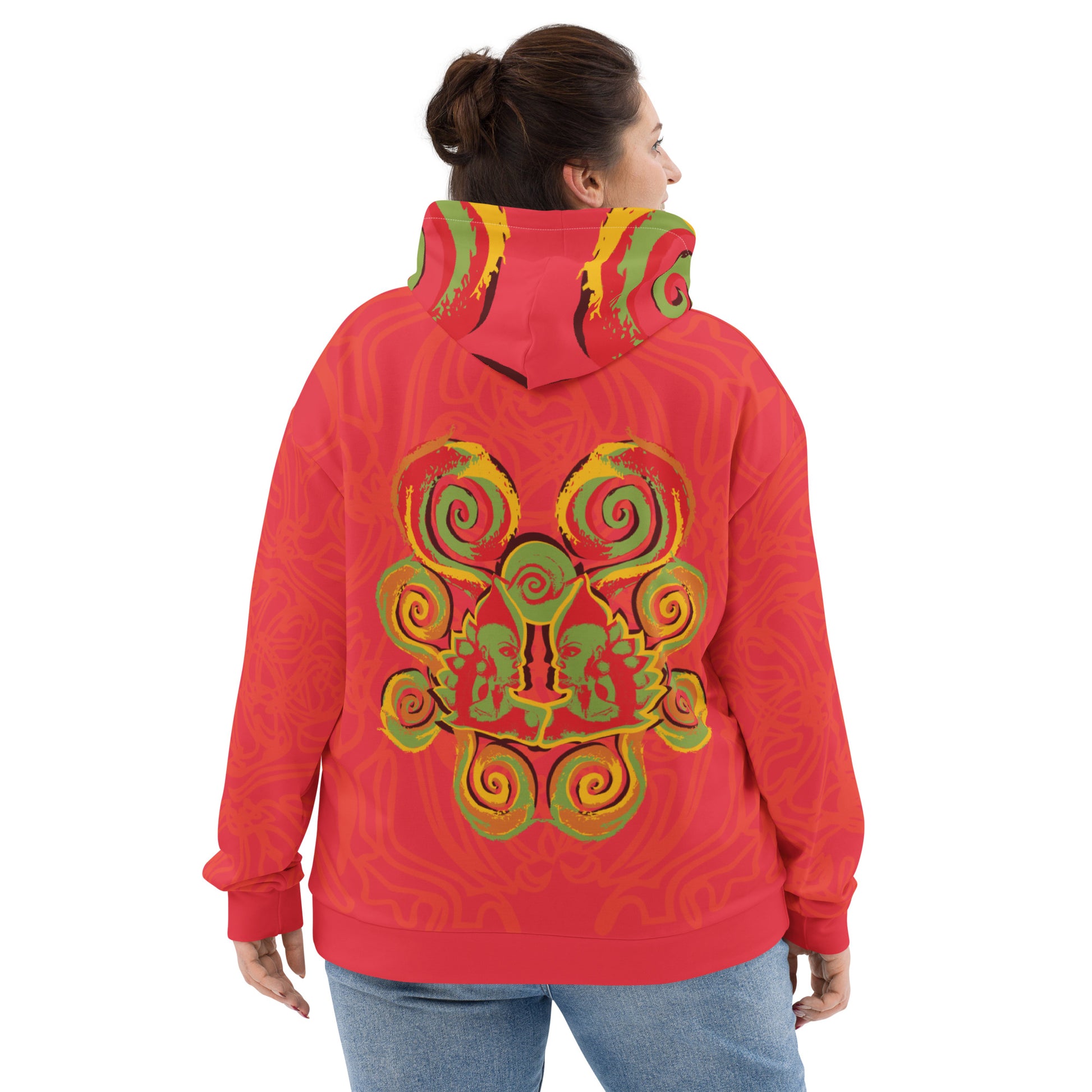 Red hoodie with bold spiral pocket design and mirrored face artwork on the back, inspired by cultural art and self-expression.