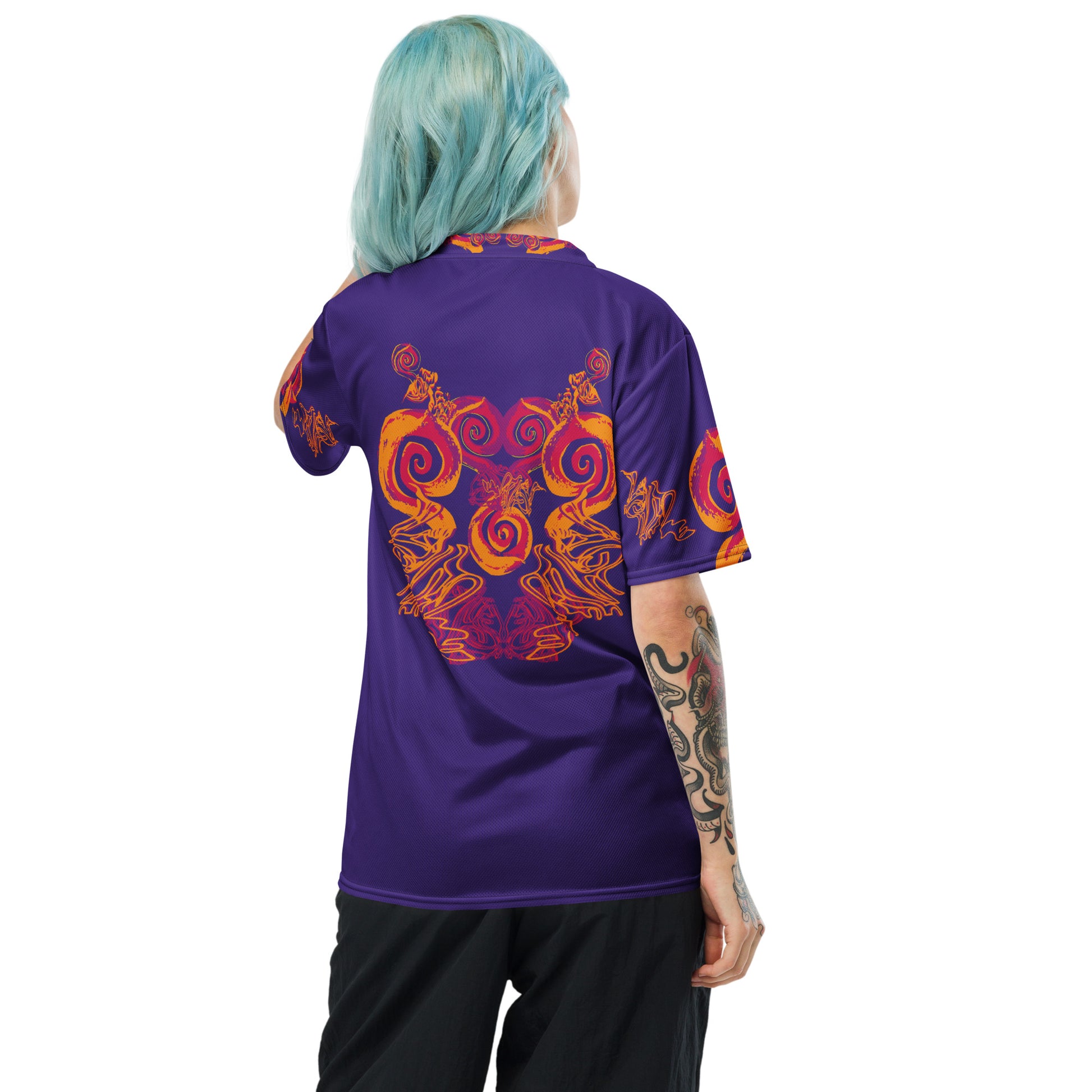 Back view of a vibrant purple sports jersey with bold orange and red culturally inspired patterns and swirling designs – expressive fashion from KLOE’s The Secret Chambers of I & I collection, worn by a model.
