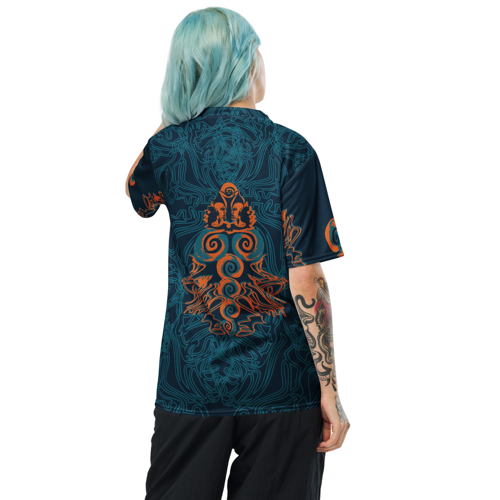 Back view of a navy blue sports jersey showcasing swirling cyan patterns and a striking orange tribal-inspired emblem, blending cultural artistry with modern streetwear.