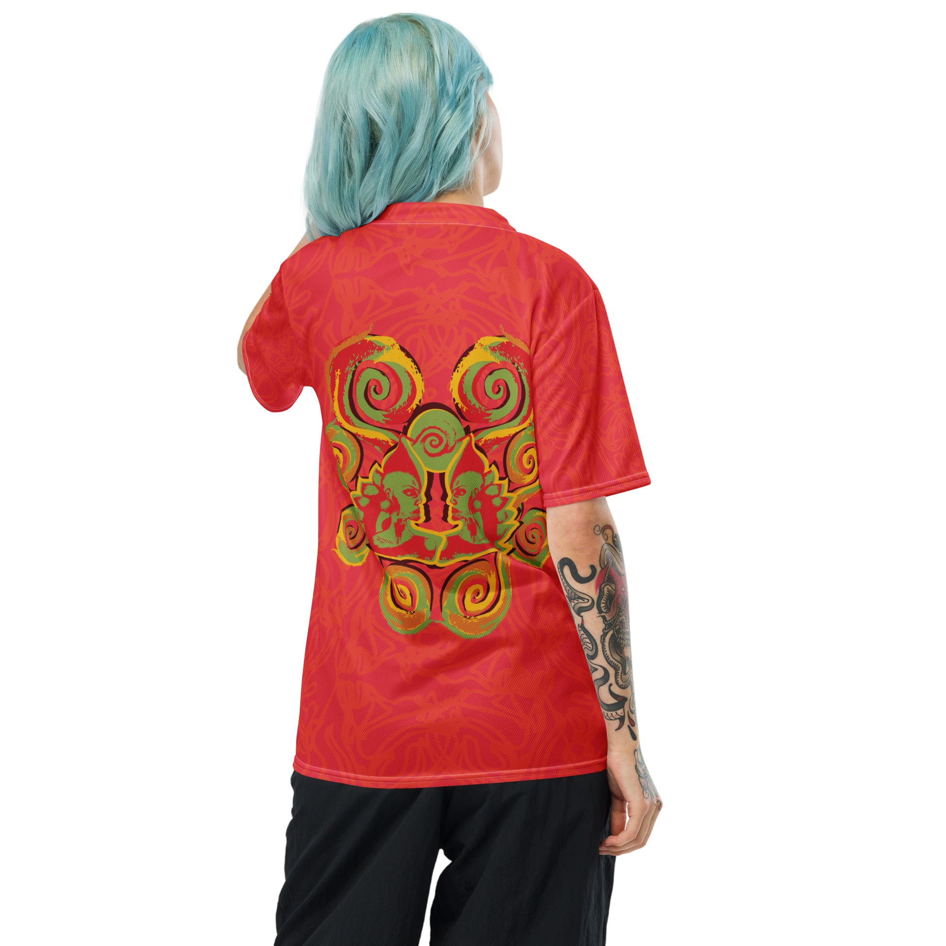 Red sports jersey with bold swirl on the front and mirrored face design on the back, inspired by cultural art and self-expression.