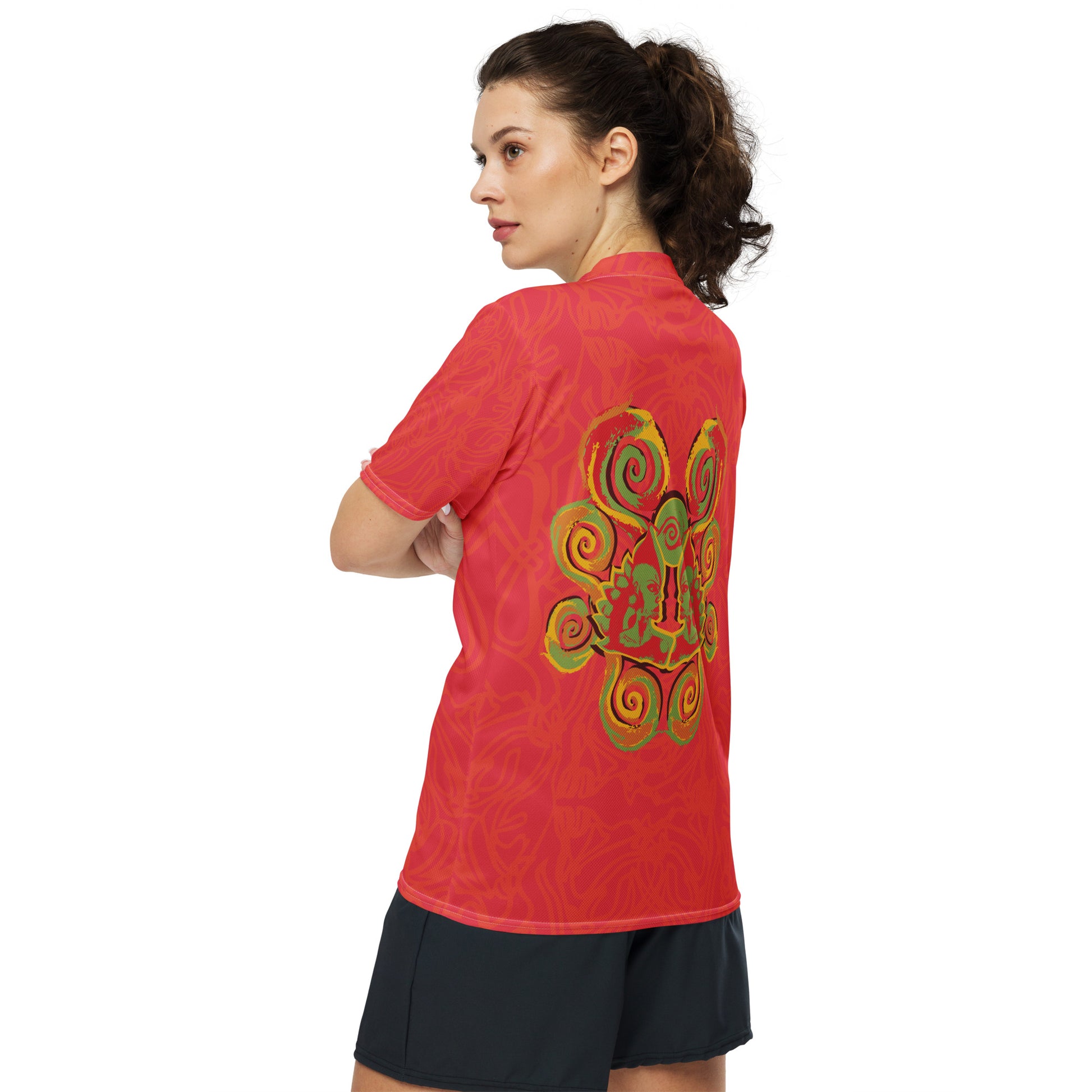 Red sports jersey with bold swirl on the front and mirrored face design on the back, inspired by cultural art and self-expression.