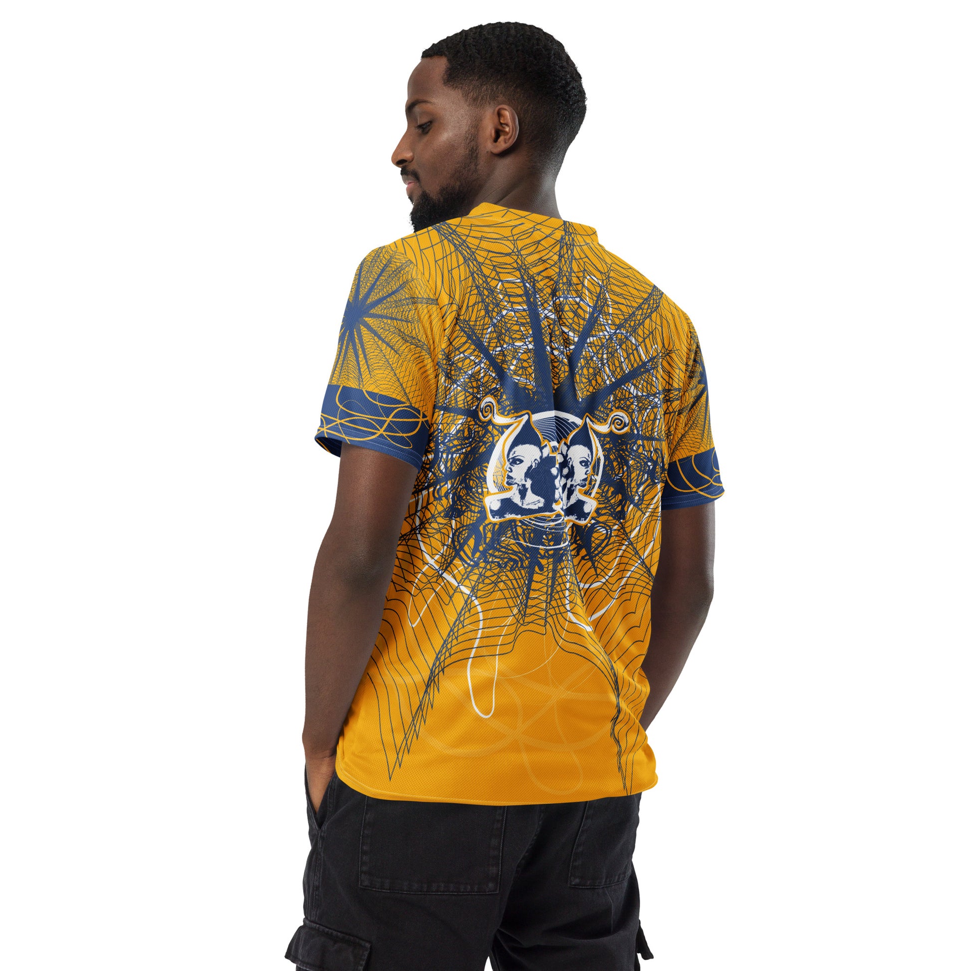 Back view of a golden yellow sports jersey showcasing layered navy geometric patterns and a mirrored face emblem, combining cultural symbolism with modern streetwear design.