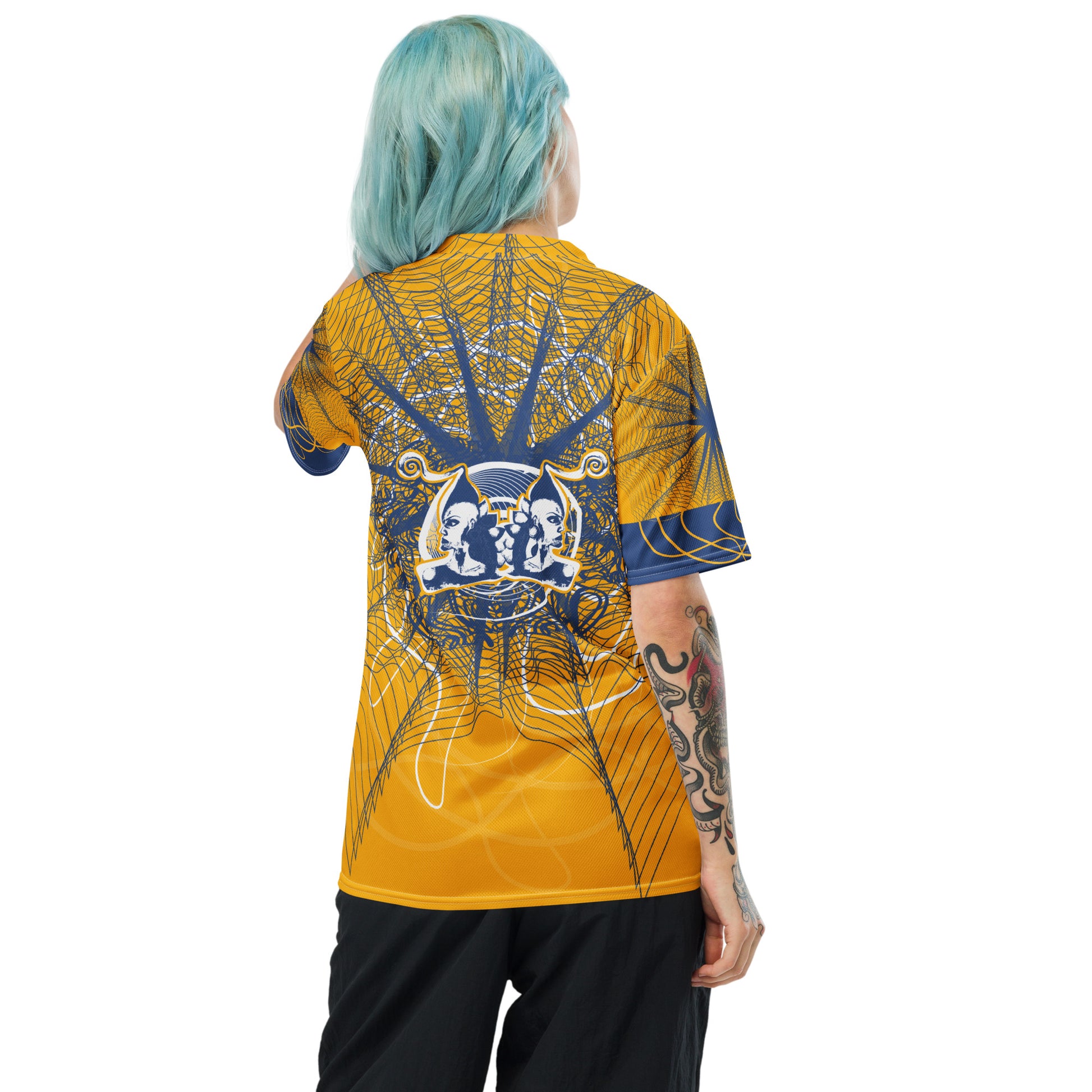 Back view of a golden yellow sports jersey showcasing layered navy geometric patterns and a mirrored face emblem, combining cultural symbolism with modern streetwear design.