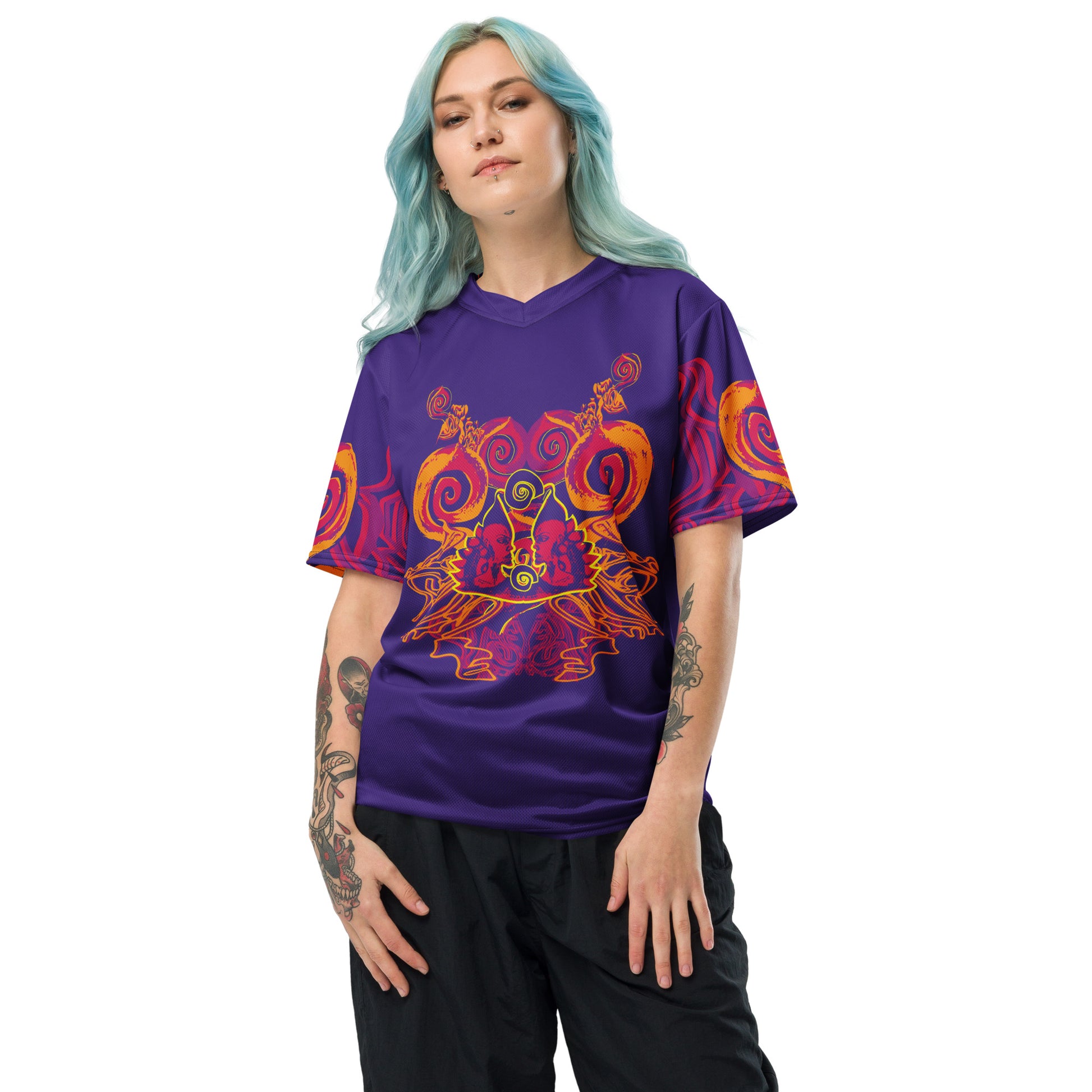 A model wearing a vibrant purple sports jersey with bold orange and red culturally inspired patterns, featuring mirrored faces and swirling designs – expressive fashion from KLOE’s The Secret Chambers of I & I collection.