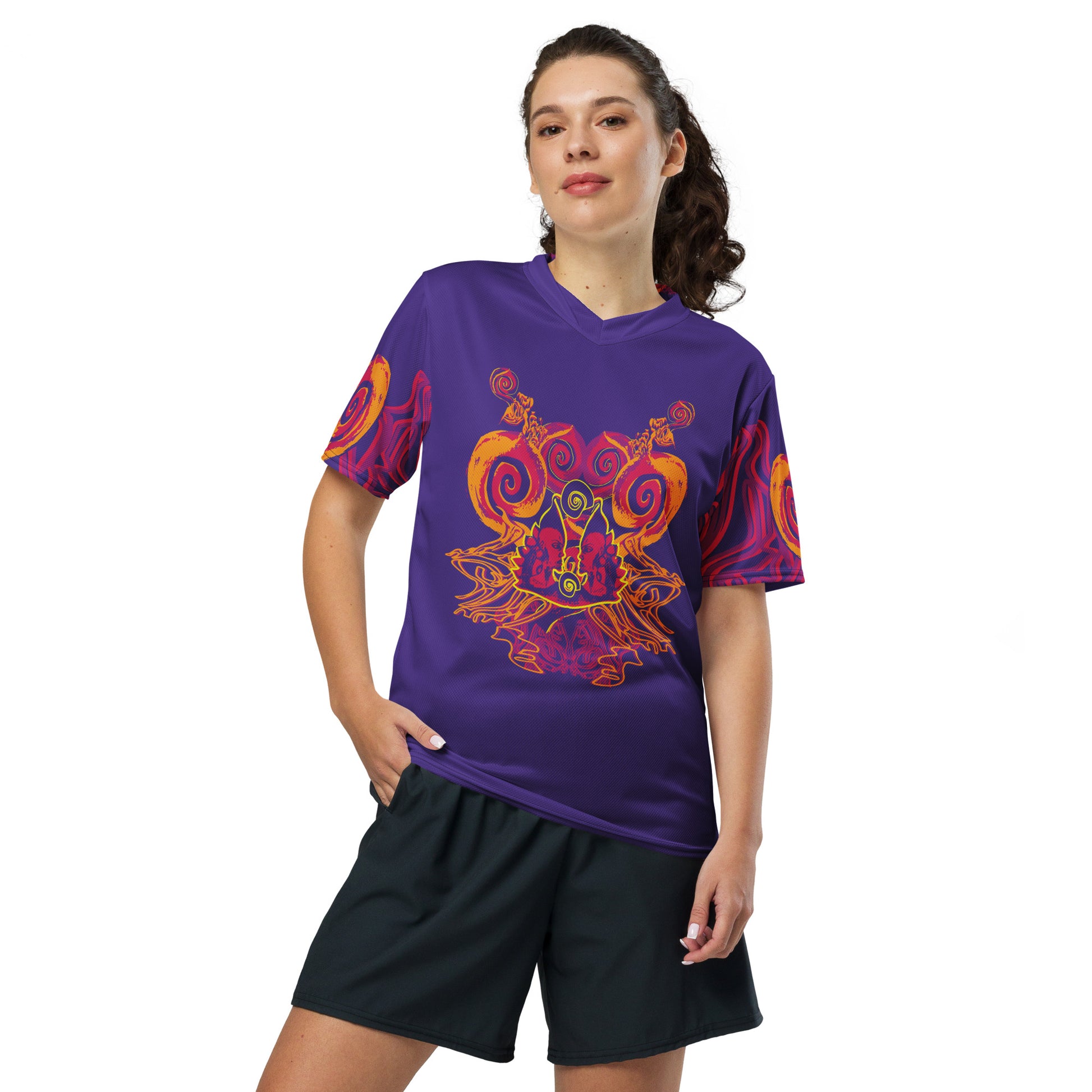A model wearing a vibrant purple sports jersey with bold orange and red culturally inspired patterns, featuring mirrored faces and swirling designs – expressive fashion from KLOE’s The Secret Chambers of I & I collection.