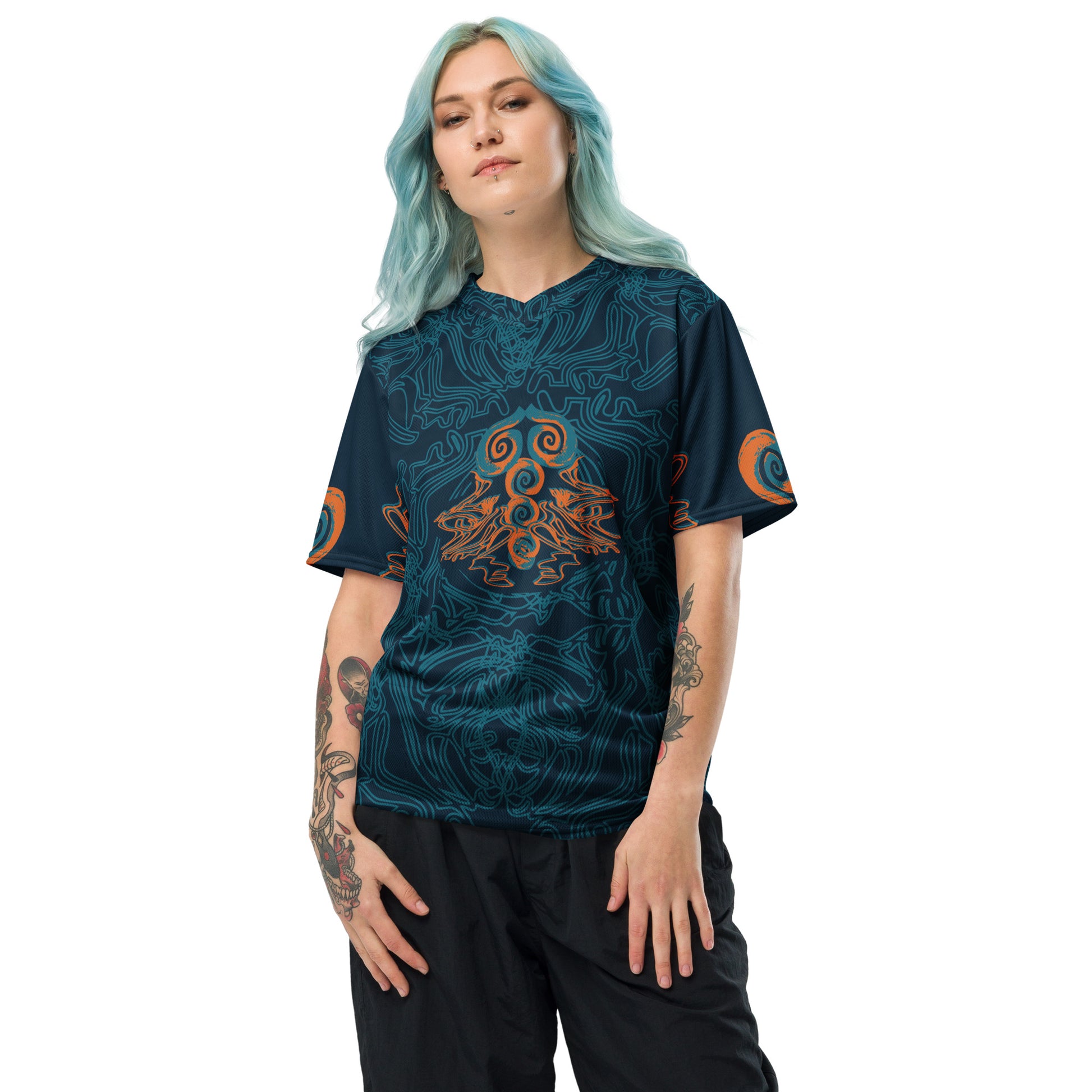 Front view of a navy blue sports jersey featuring intricate cyan line art and bold orange tribal-inspired patterns, with a mirrored abstract design at the center, on a model.