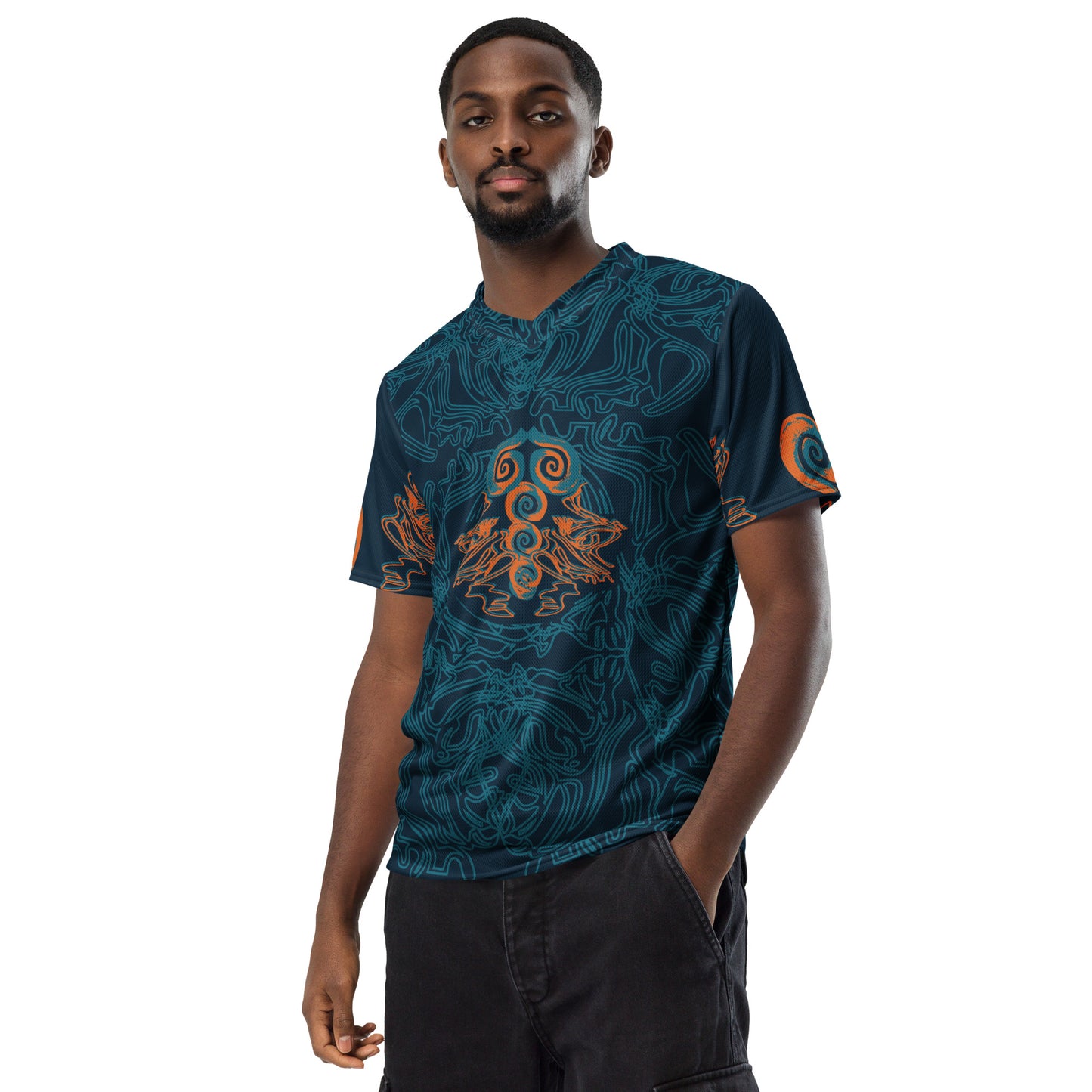 Front view of a navy blue sports jersey featuring intricate cyan line art and bold orange tribal-inspired patterns, with a mirrored abstract design at the center, on a model.