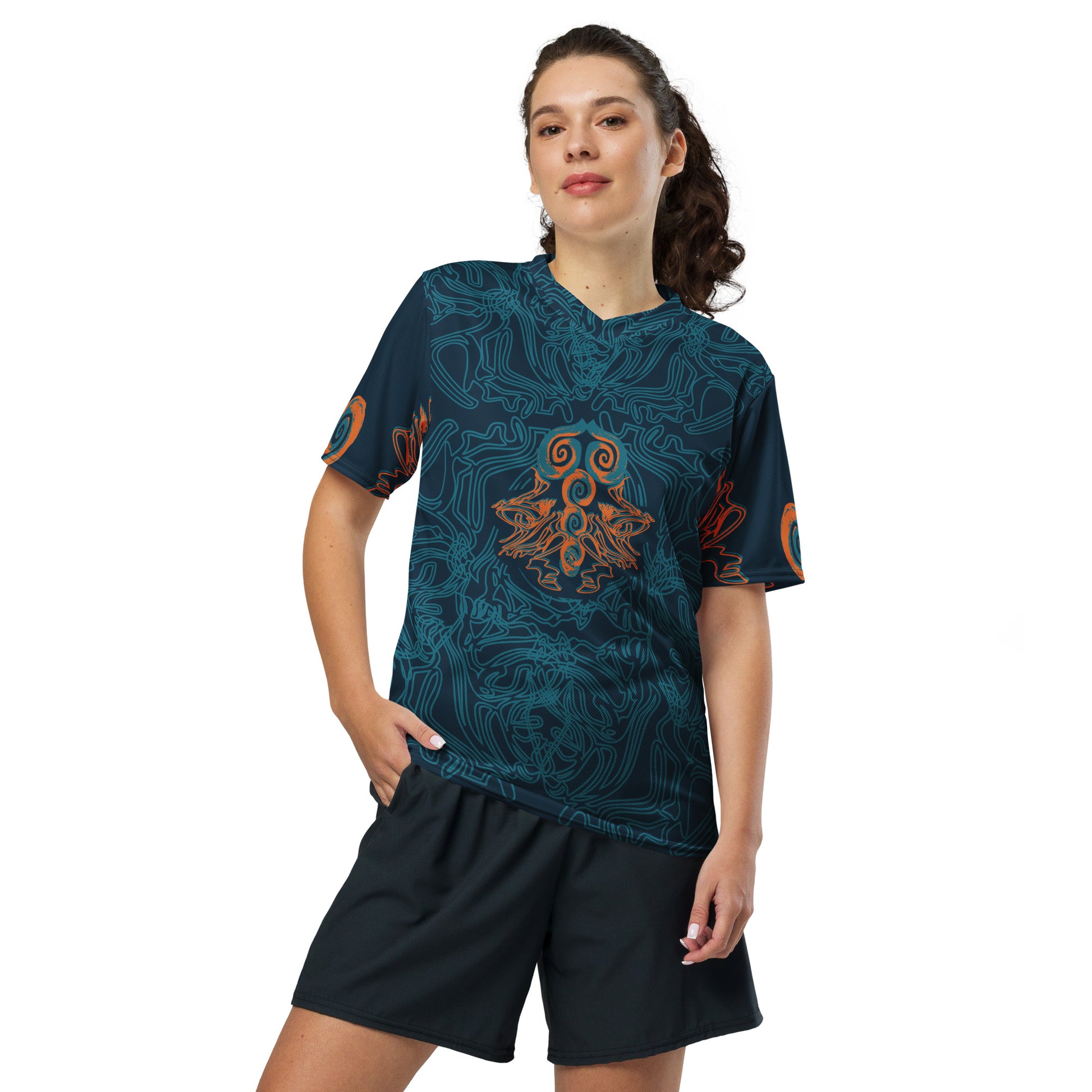 Front view of a navy blue sports jersey featuring intricate cyan line art and bold orange tribal-inspired patterns, with a mirrored abstract design at the center, on a model.