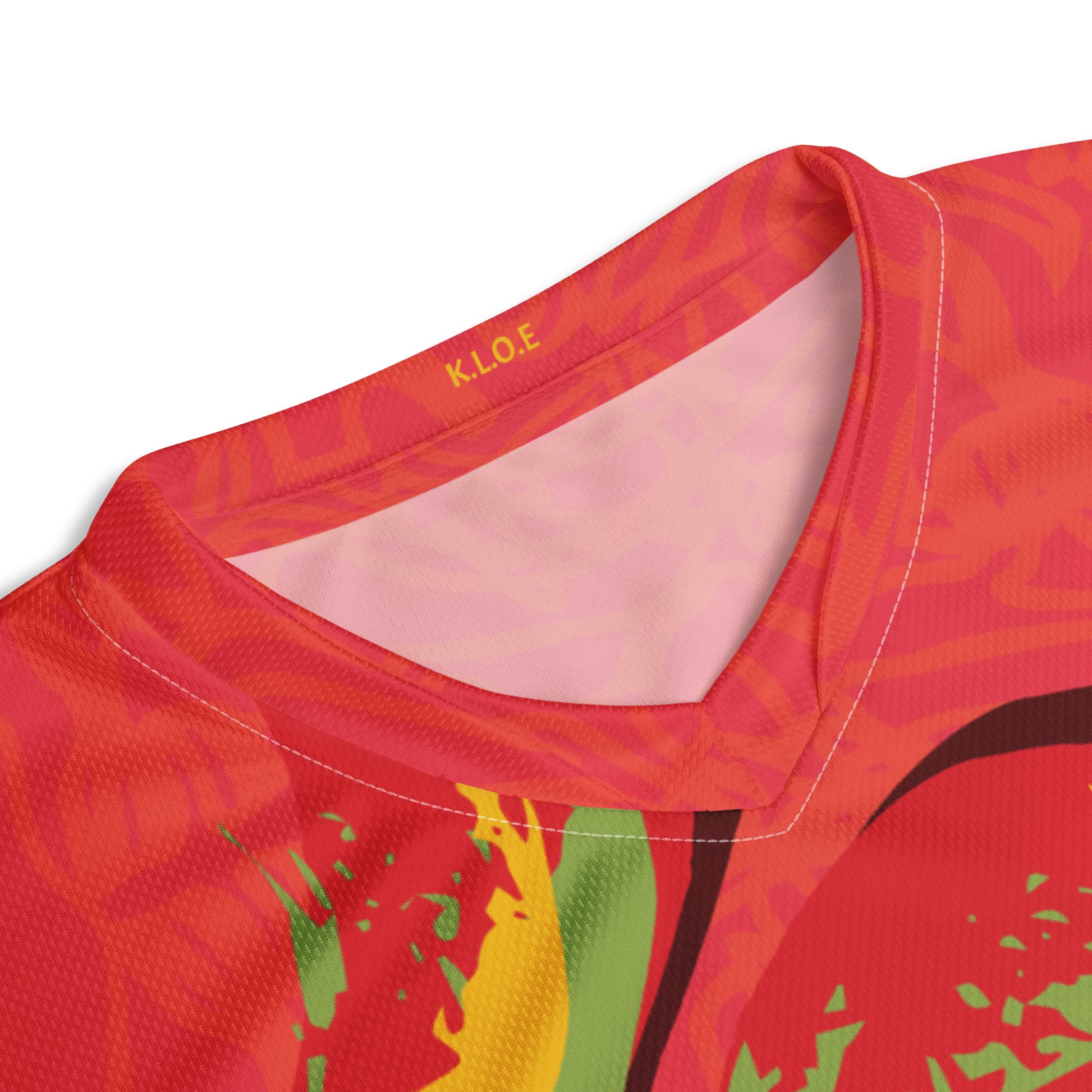 Red sports jersey with bold swirl on the front and mirrored face design on the back, inspired by cultural art and self-expression.