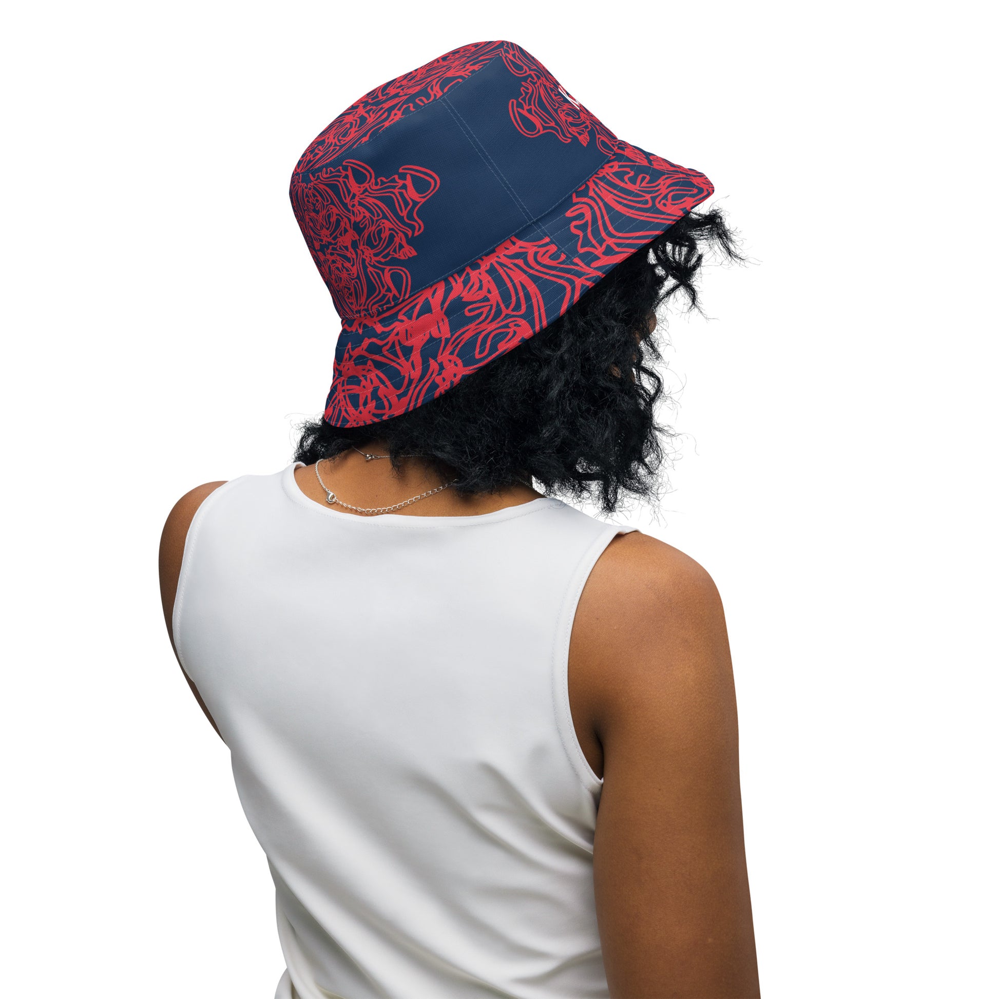 Bold reversible streetwear bucket hat featuring hand-drawn tribal patterns on one side and a mirrored face design on the other, crafted in navy and red for an edgy, modern look – KLOE fashion.