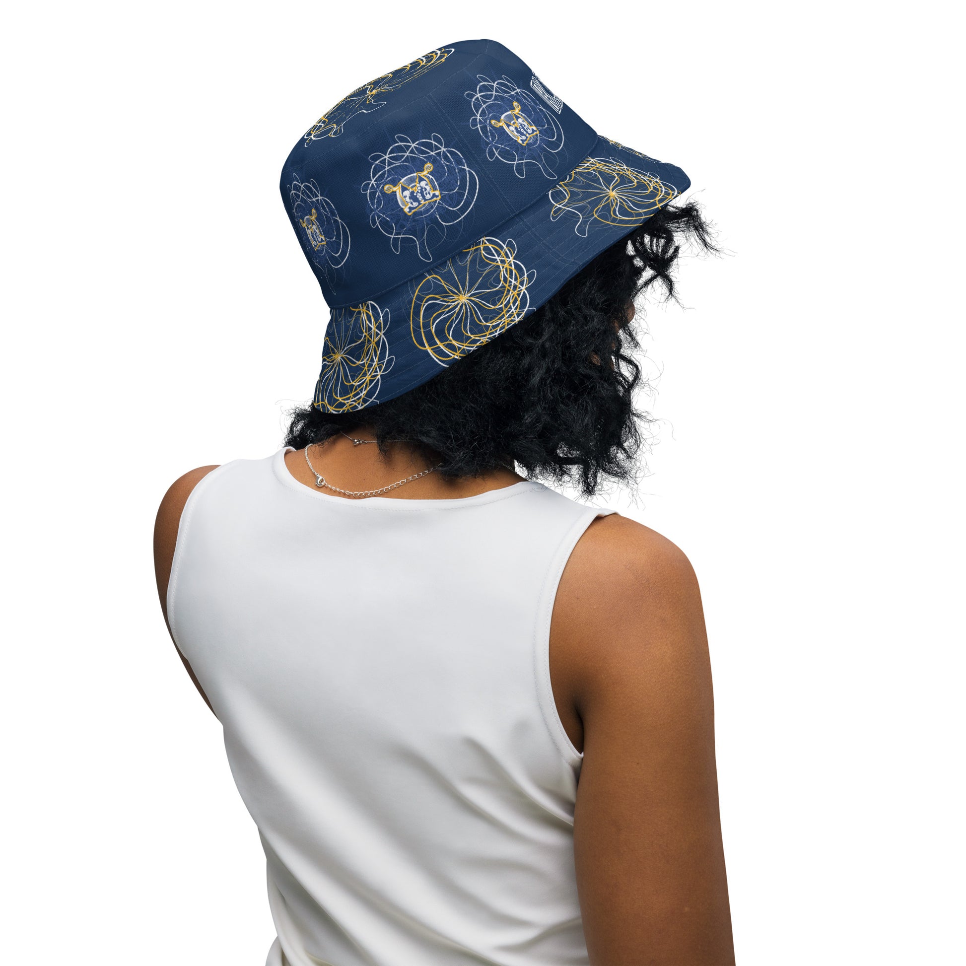Reversible bucket hat featuring navy and golden yellow sides with abstract white linework and mirrored face emblems, blending hand-drawn cultural art with bold, expressive streetwear style.