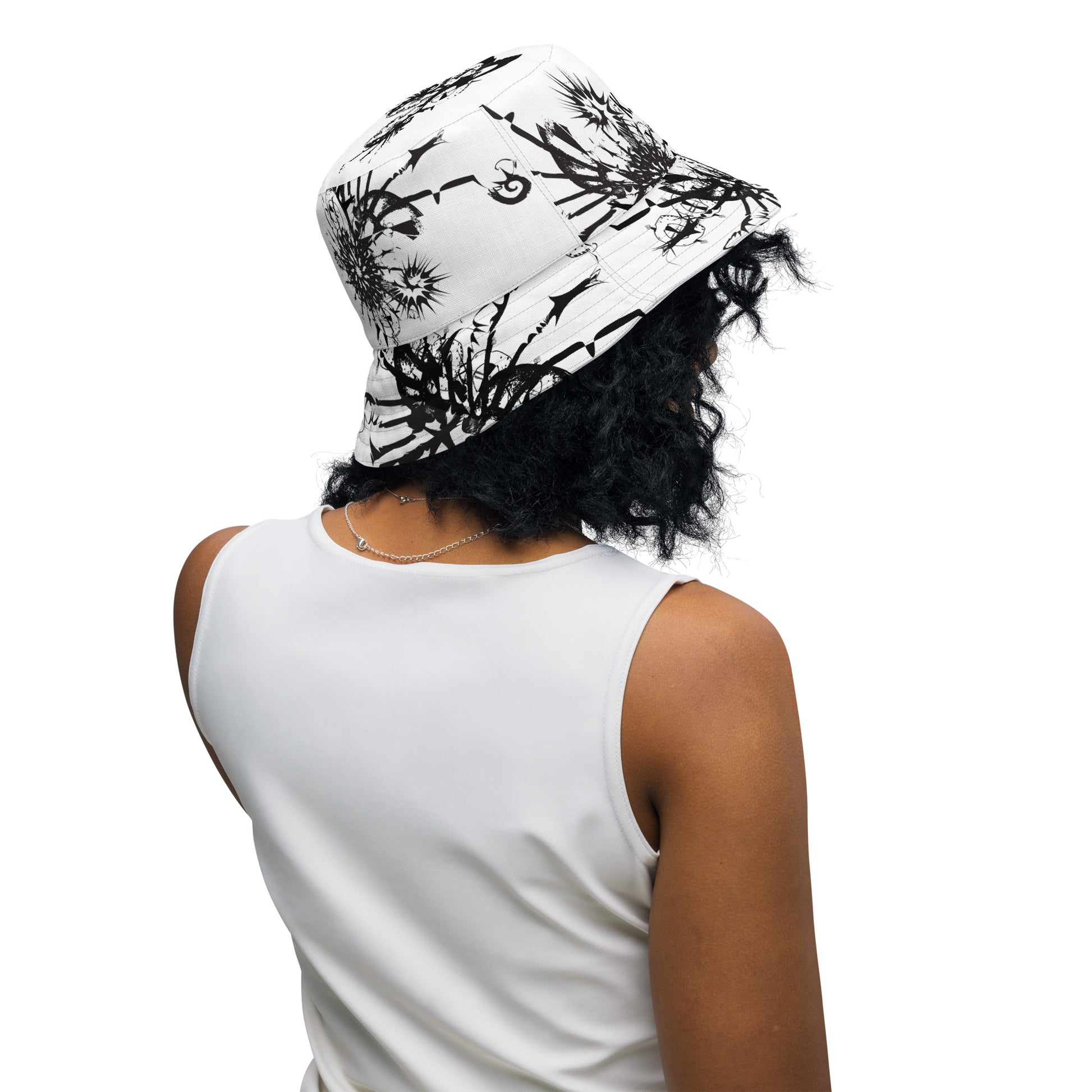 All-over print reversible bucket hat by K.L.O.E featuring black hand-drawn, culturally inspired artwork on a white background—expressing individuality and transformation through intricate abstract symbolism.