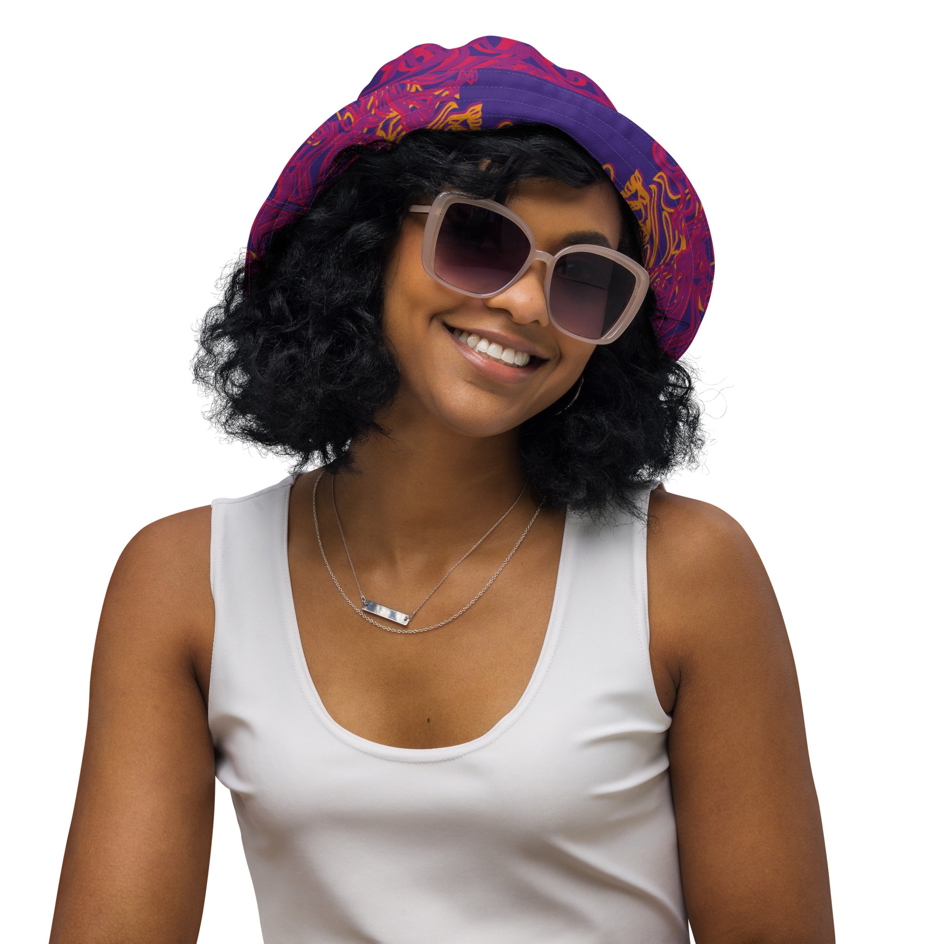 Reversible purple bucket hat with bold orange and red culturally inspired patterns, featuring abstract swirls and mirrored face design — artistic fashion accessory from KLOE’s The Secret Chambers of I & I collection, on a model.