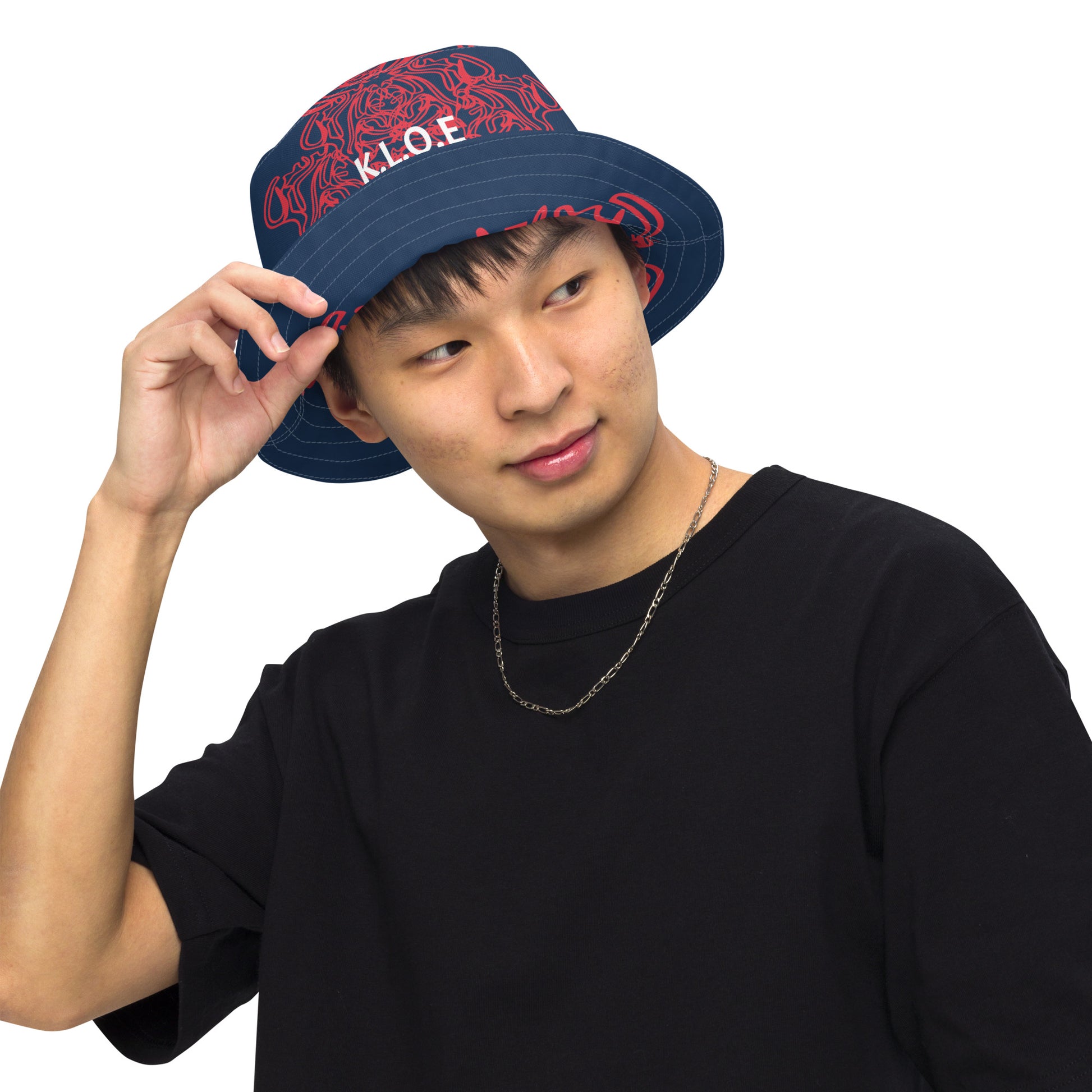 Bold reversible streetwear bucket hat featuring hand-drawn tribal patterns on one side and a mirrored face design on the other, crafted in navy and red for an edgy, modern look – KLOE fashion.