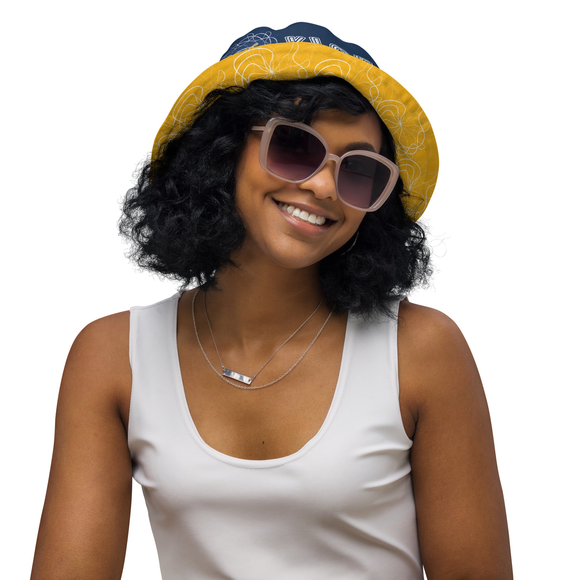 Reversible bucket hat featuring navy and golden yellow sides with abstract white linework and mirrored face emblems, blending hand-drawn cultural art with bold, expressive streetwear style.