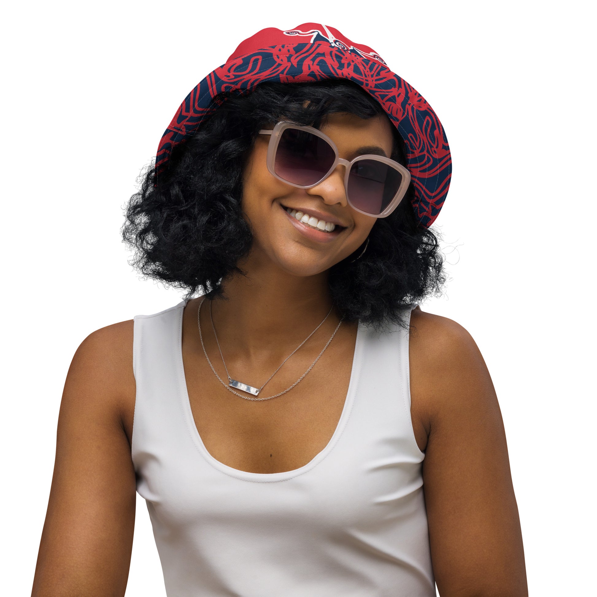 Bold reversible streetwear bucket hat featuring hand-drawn tribal patterns on one side and a mirrored face design on the other, crafted in navy and red for an edgy, modern look – KLOE fashion.