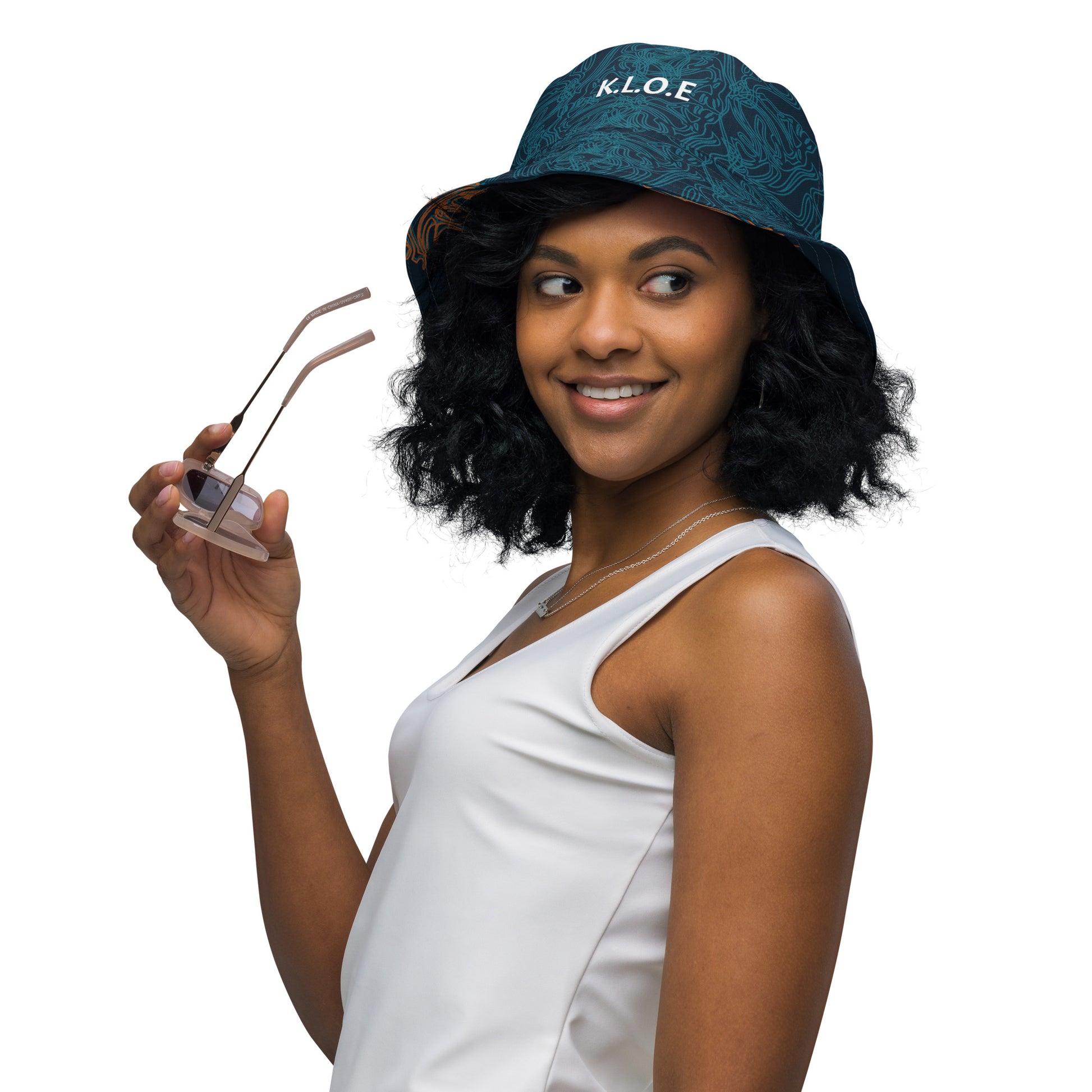 Navy blue bucket hat with cyan line art and 'K.L.O.E' branding on the front, offering a minimal yet artistic aesthetic, worn by a model.