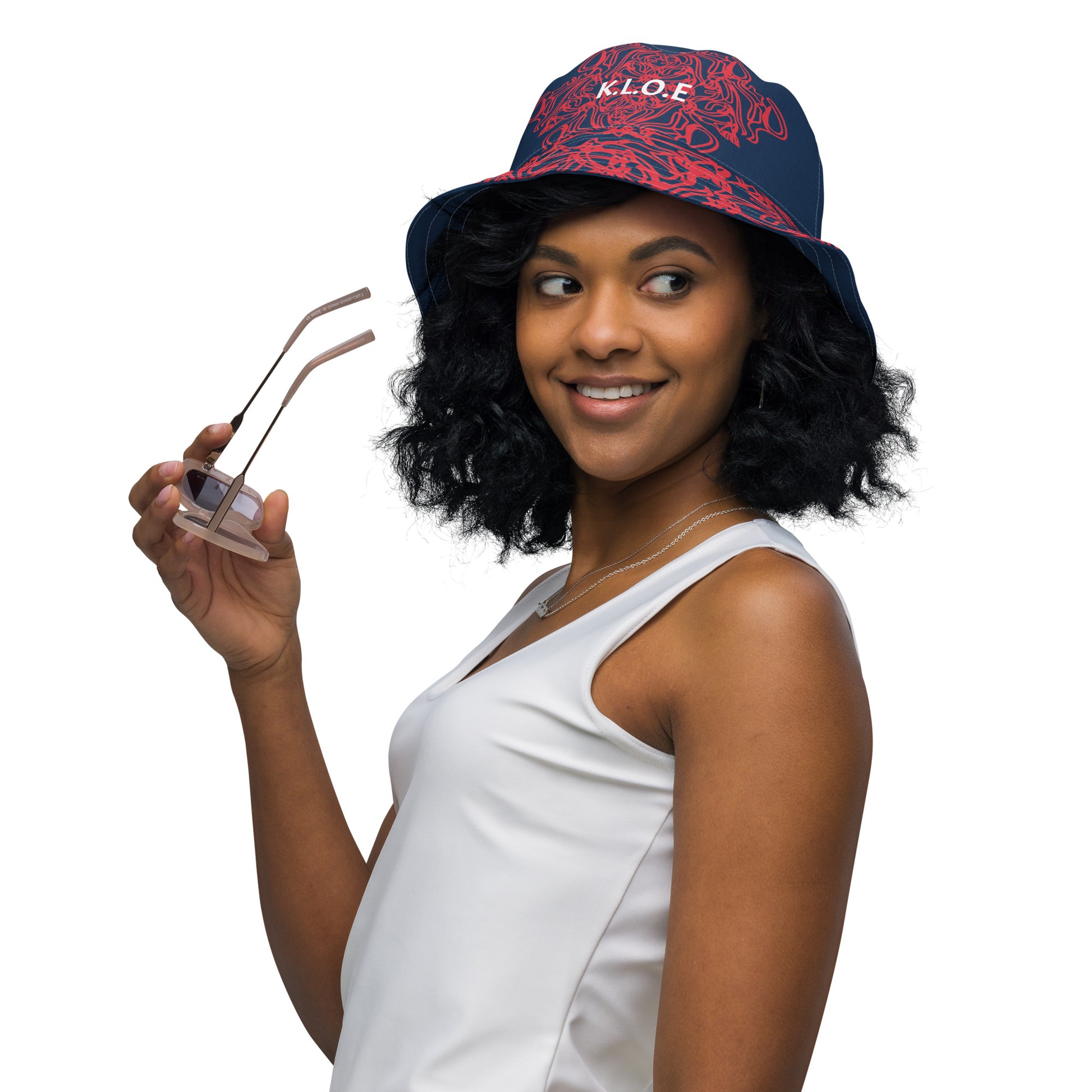 Bold reversible streetwear bucket hat featuring hand-drawn tribal patterns on one side and a mirrored face design on the other, crafted in navy and red for an edgy, modern look – KLOE fashion.