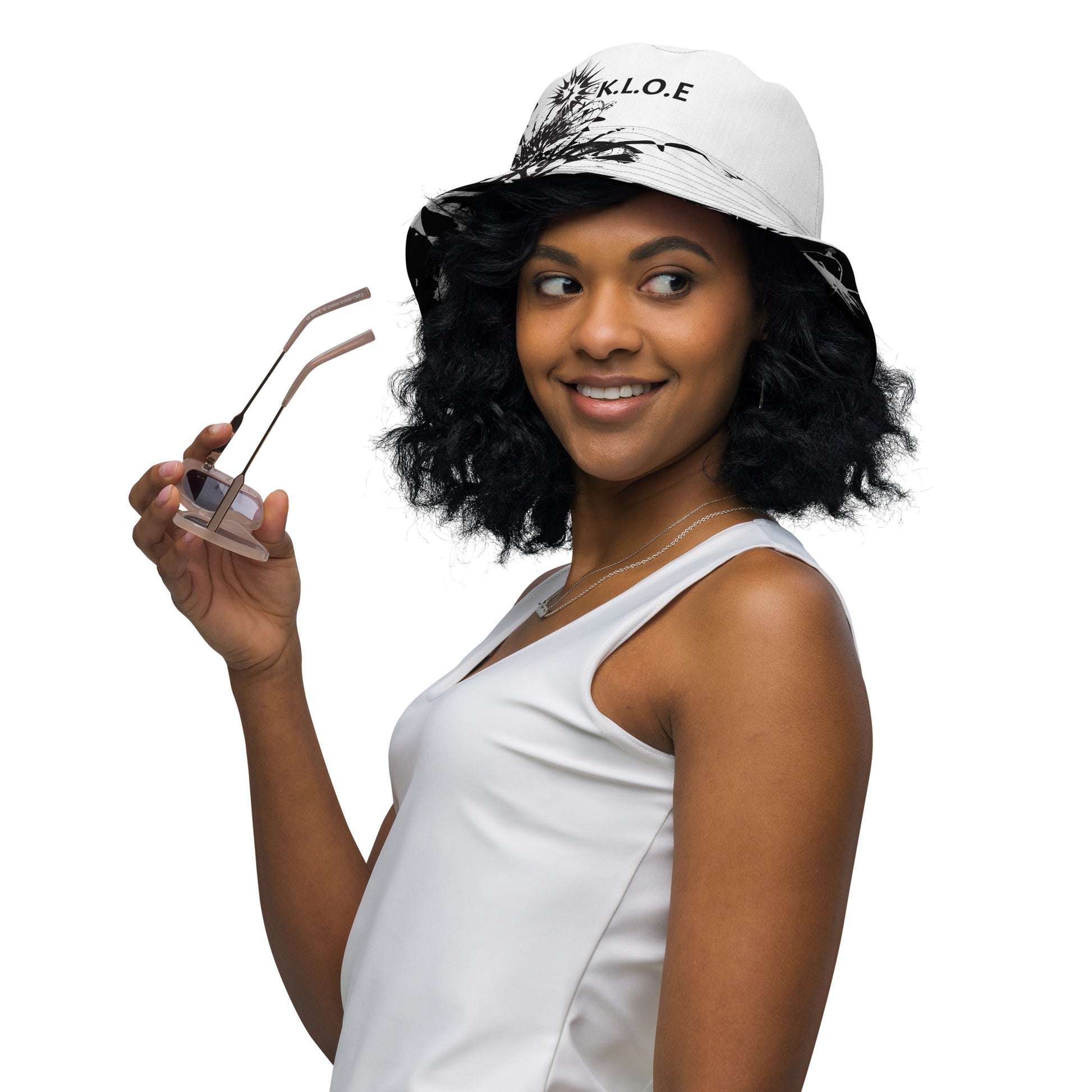 All-over print reversible bucket hat by K.L.O.E featuring black hand-drawn, culturally inspired artwork on a white background—expressing individuality and transformation through intricate abstract symbolism.