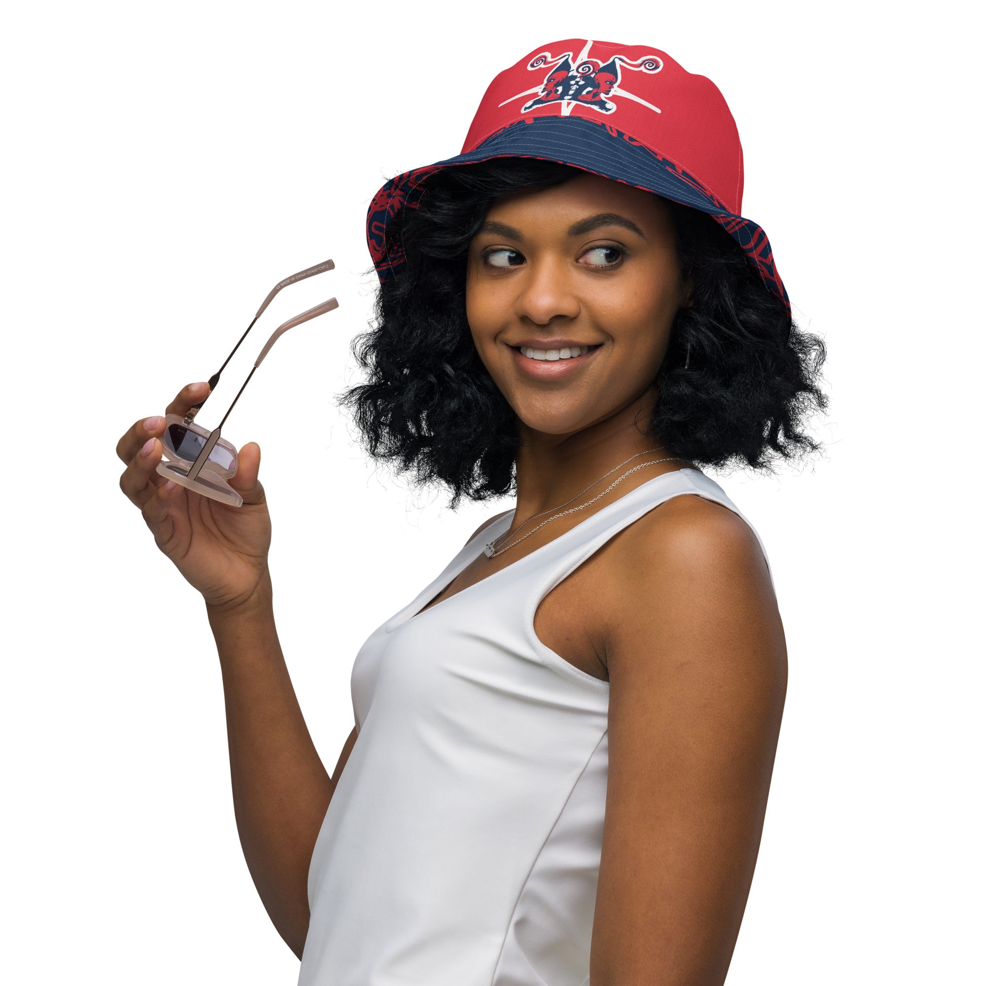 Bold reversible streetwear bucket hat featuring hand-drawn tribal patterns on one side and a mirrored face design on the other, crafted in navy and red for an edgy, modern look – KLOE fashion.