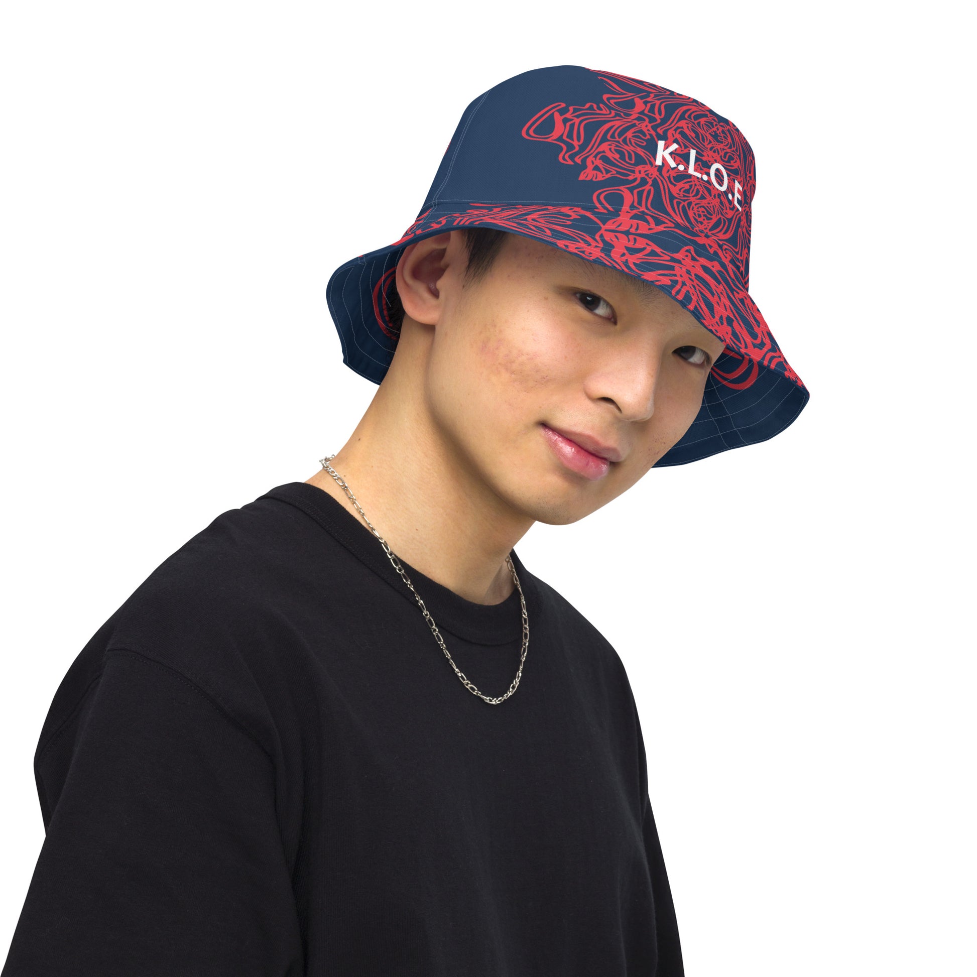 Bold reversible streetwear bucket hat featuring hand-drawn tribal patterns on one side and a mirrored face design on the other, crafted in navy and red for an edgy, modern look – KLOE fashion.