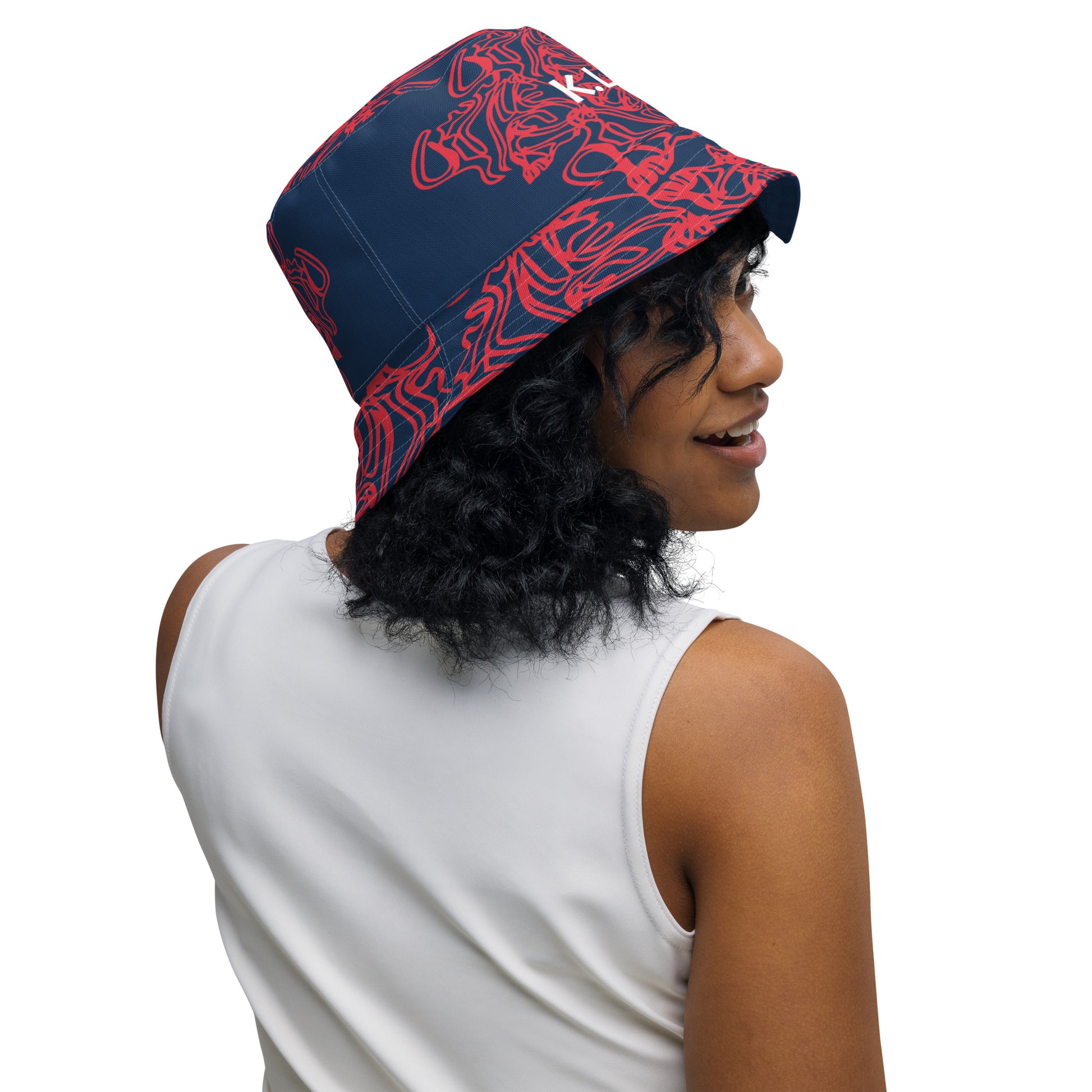 Bold reversible streetwear bucket hat featuring hand-drawn tribal patterns on one side and a mirrored face design on the other, crafted in navy and red for an edgy, modern look – KLOE fashion.