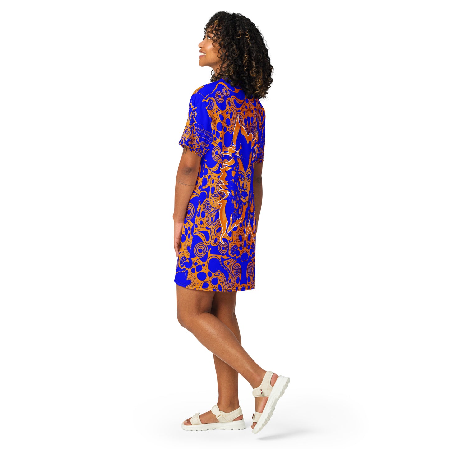 A model wearing bold blue and orange t-shirt dress from Kloe Store featuring intricate abstract patterns and a central artistic face design, offering a stylish and edgy streetwear look.