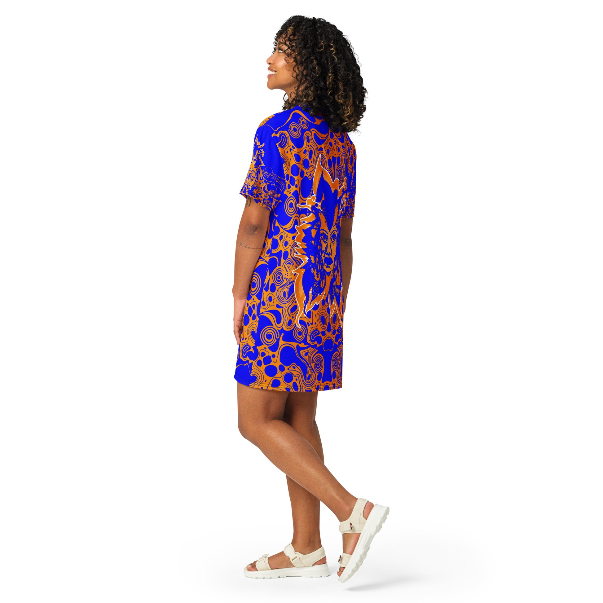 A model wearing bold blue and orange t-shirt dress from Kloe Store featuring intricate abstract patterns and a central artistic face design, offering a stylish and edgy streetwear look.