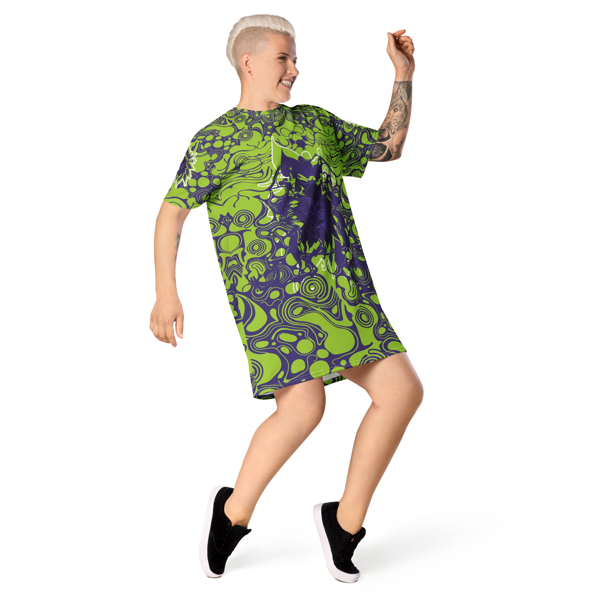 A model wearing green and purple t-shirt dress from Kloe Store featuring bold abstract patterns and a unique central artistic face design, perfect for a trendy and edgy streetwear style.